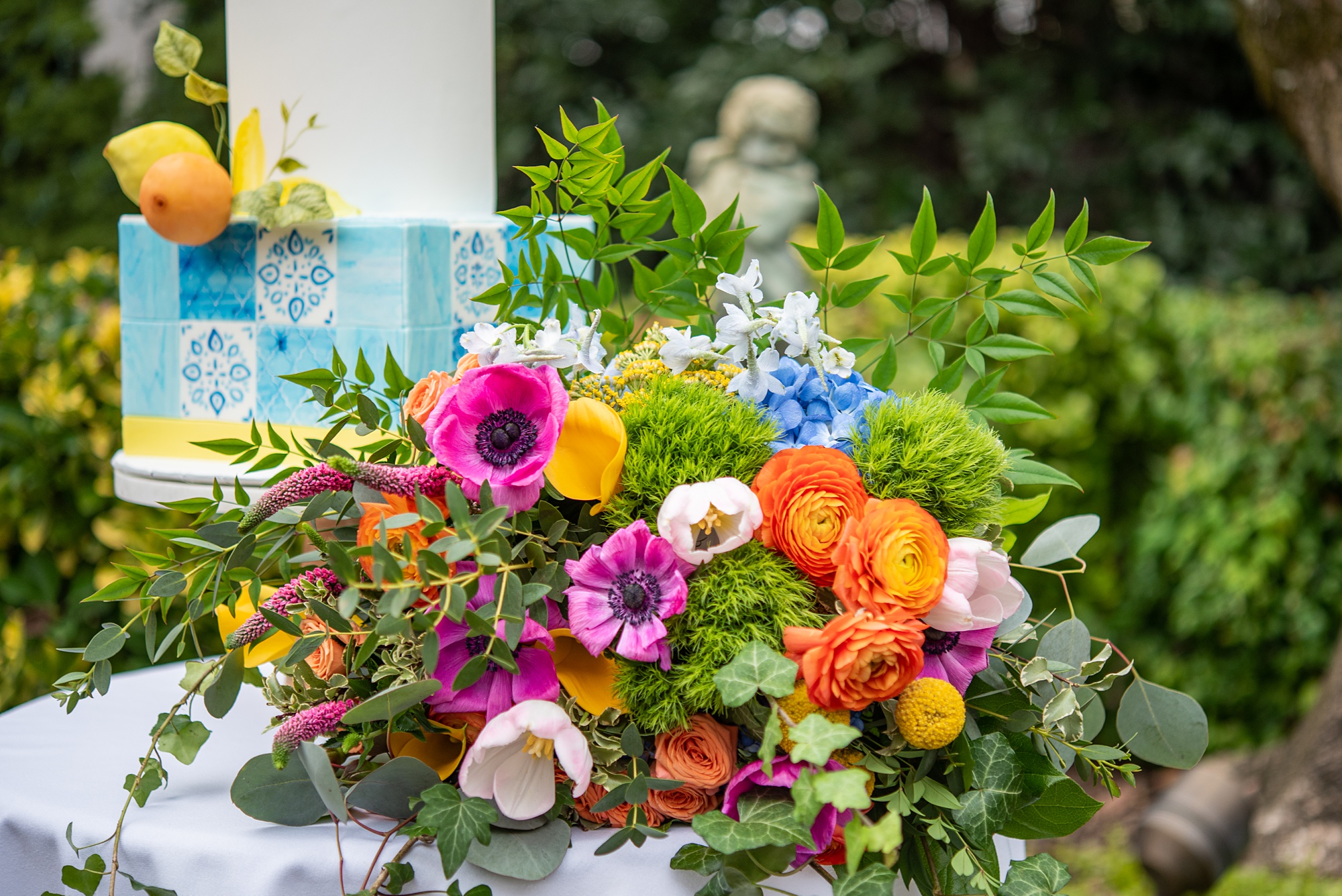 colorful bouquet sits by wedding cake during Italian inspired microwedding