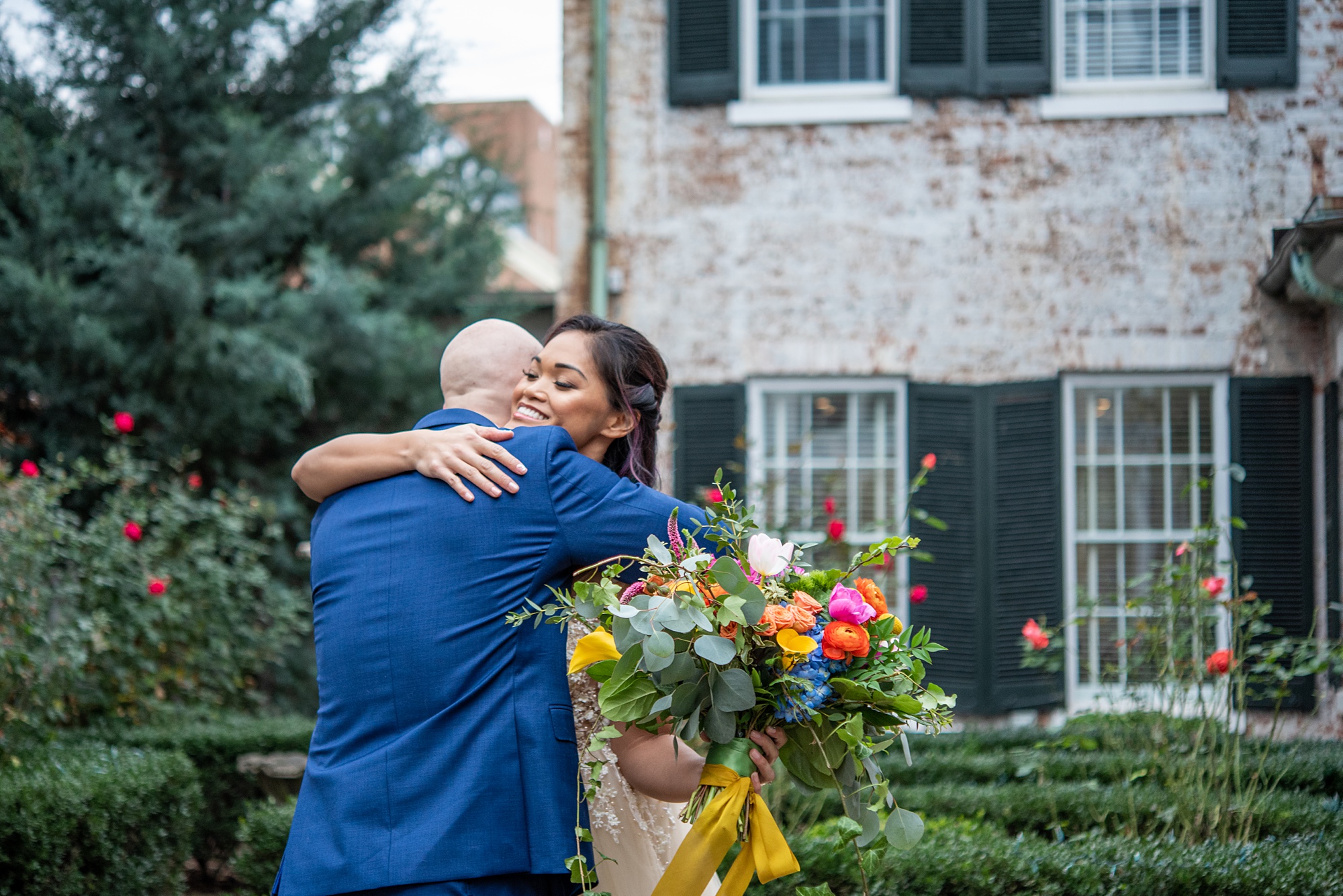 couple hugs during first look in courtyard of Old Town Alexandria building 