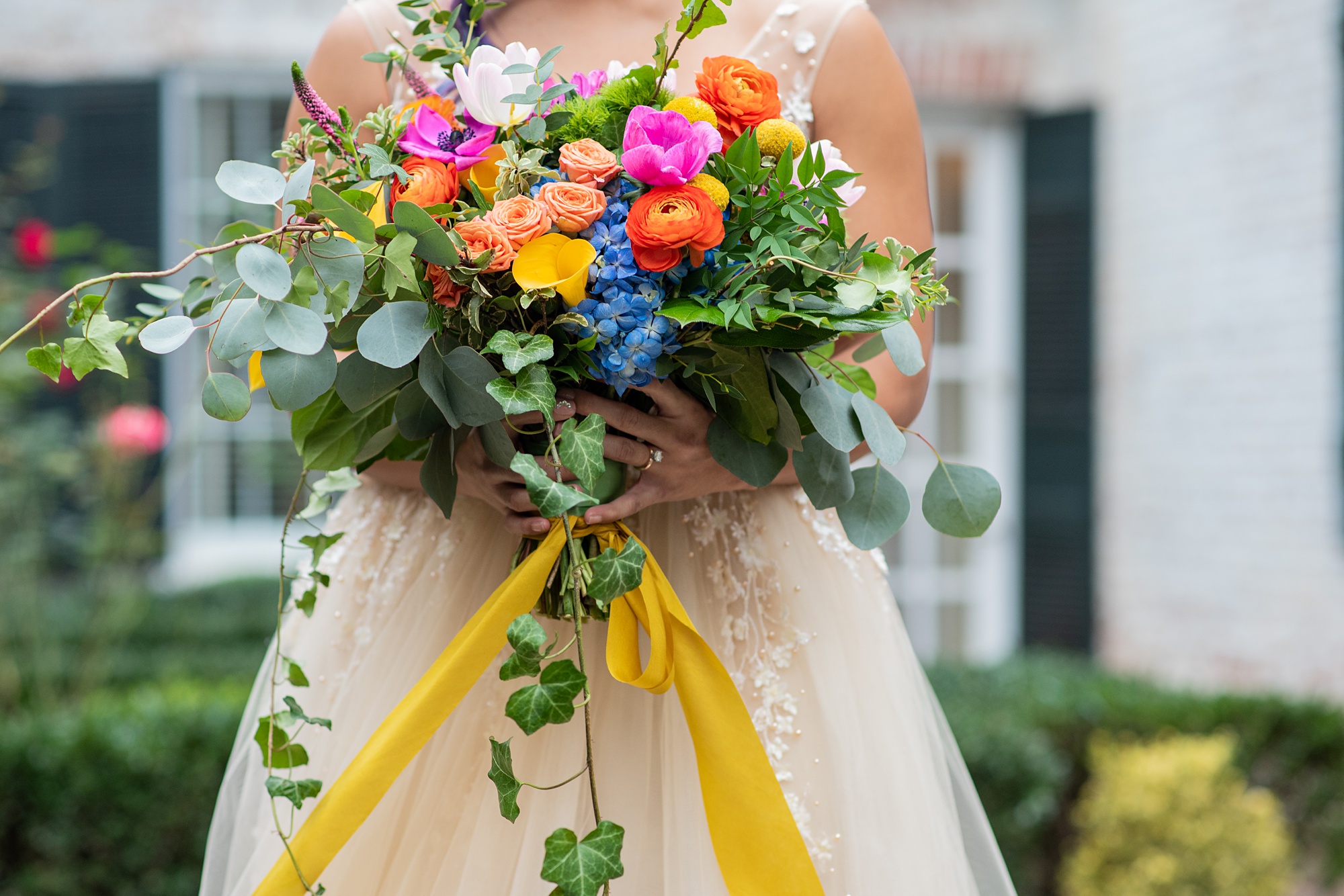 bride holds bouquet of colorful flowers during Italian inspired microwedding styled shoot