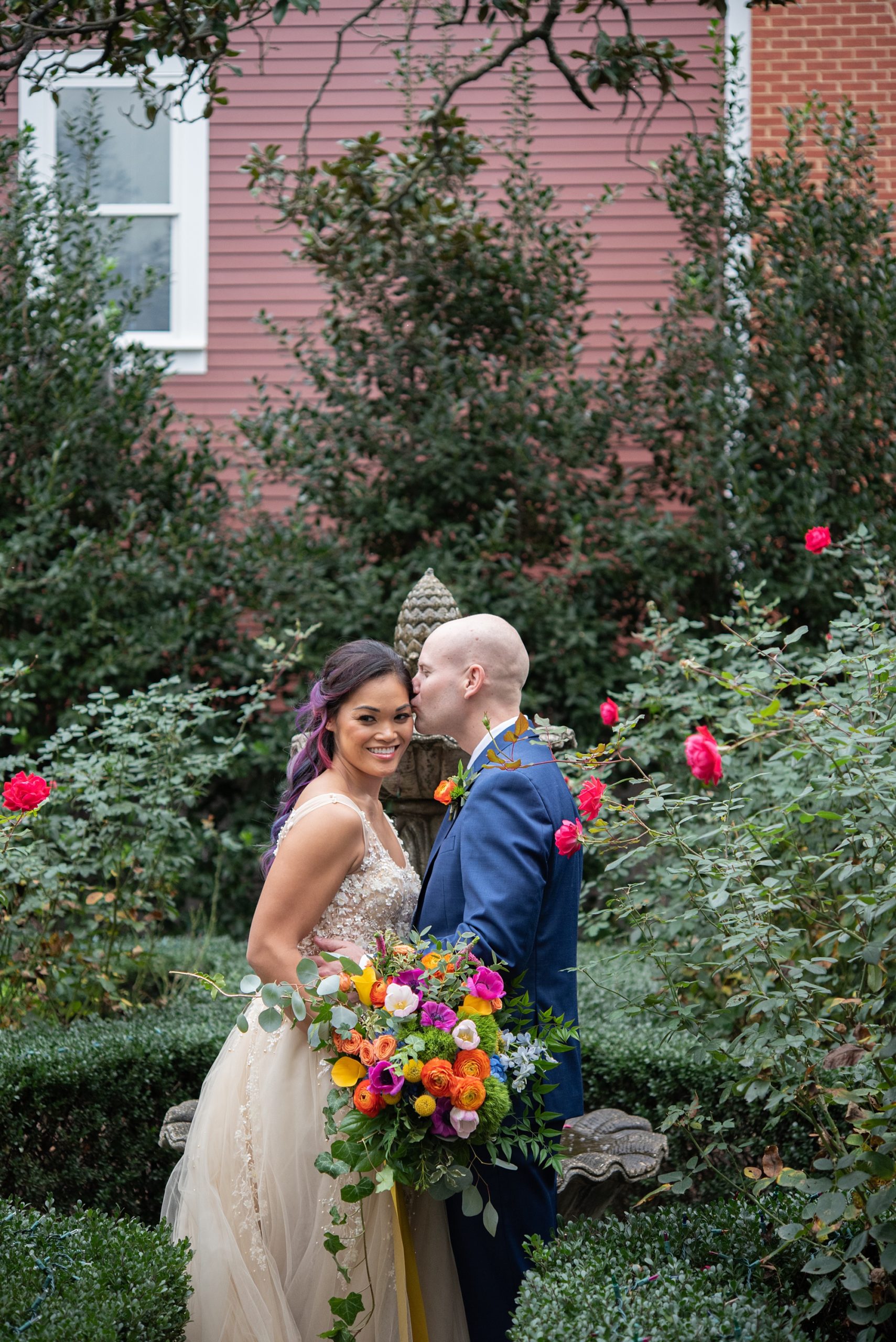 bride and groom kiss in gardens of Old Town Alexandria