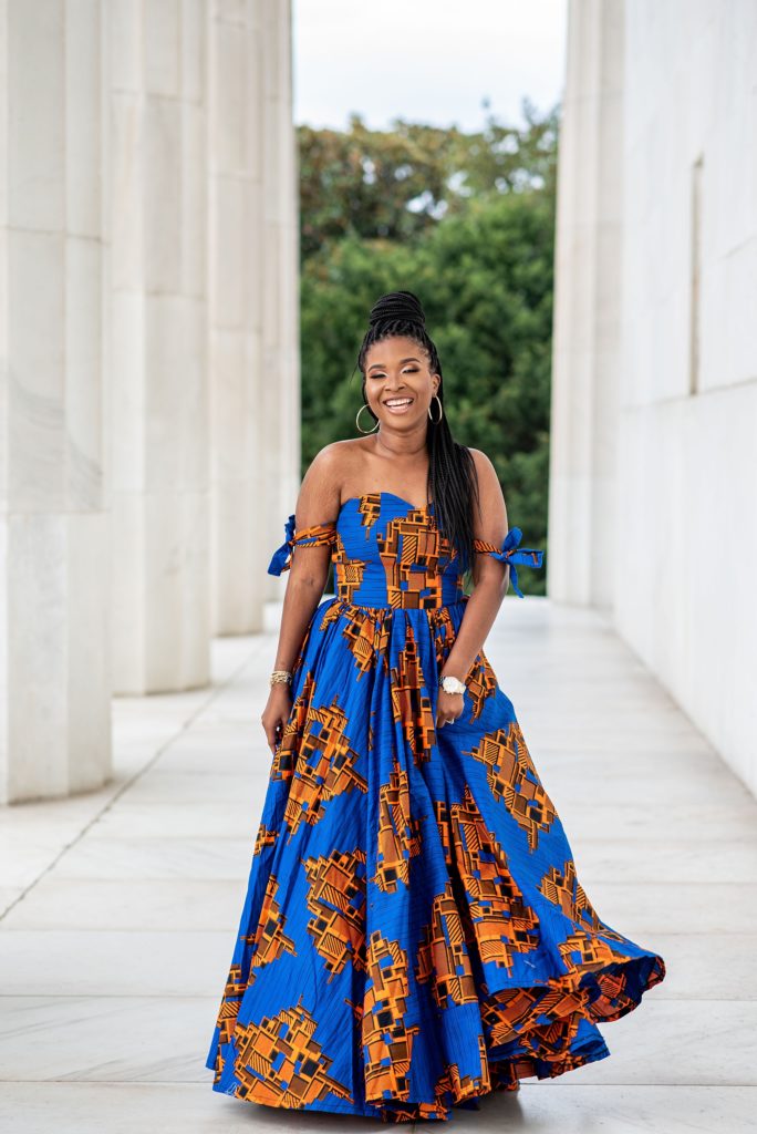 bride twirls blue and orange African dress during Lincoln Memorial engagement session