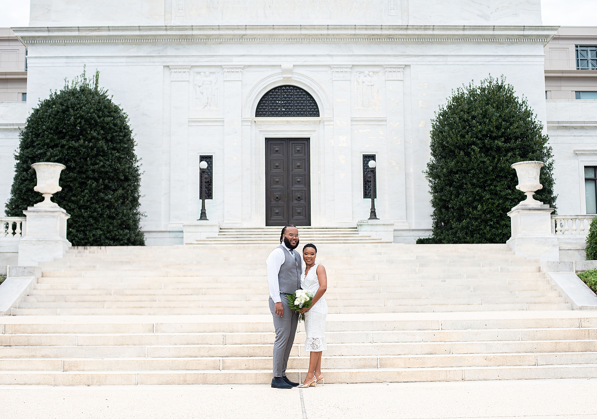 married couple poses in front of American Institute of Pharmacy