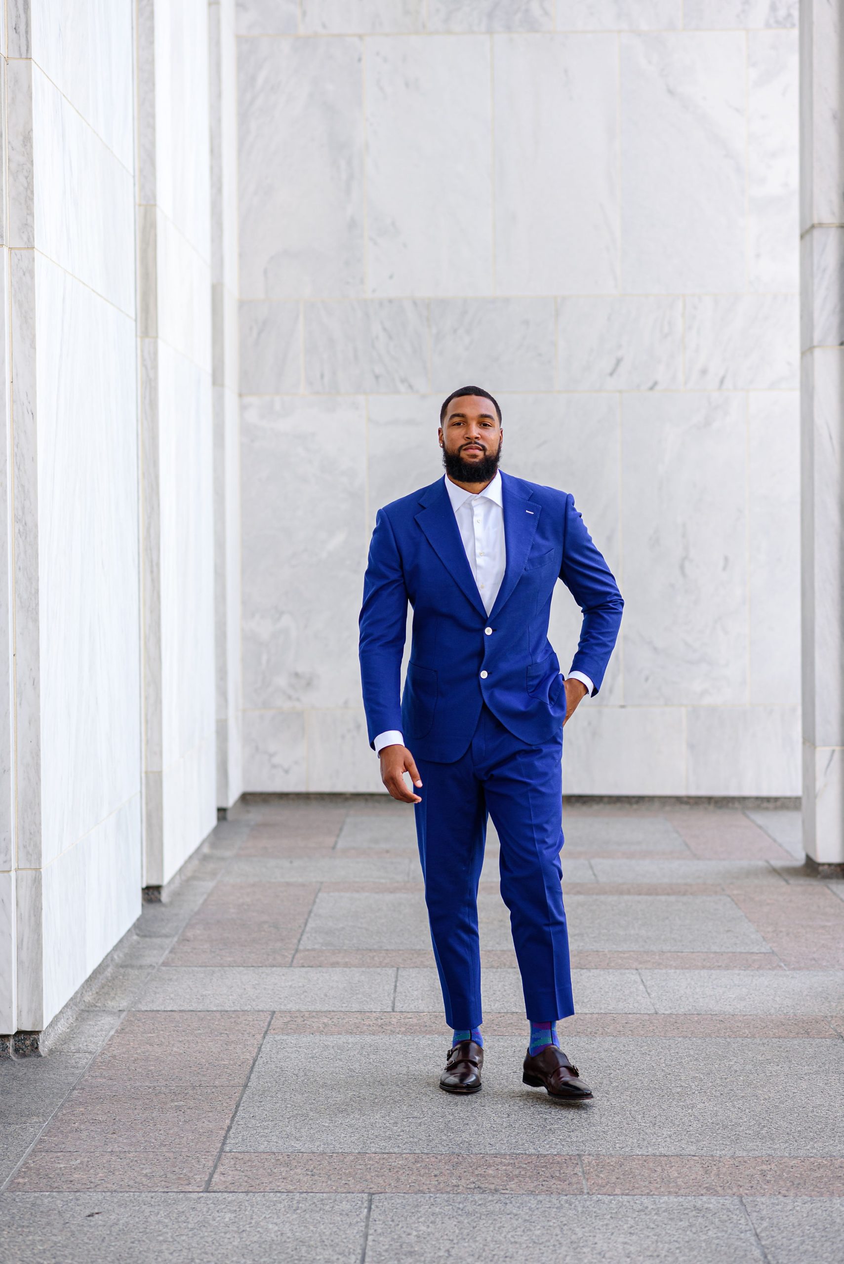 husband in blue suit walks through Library of Congress pillars