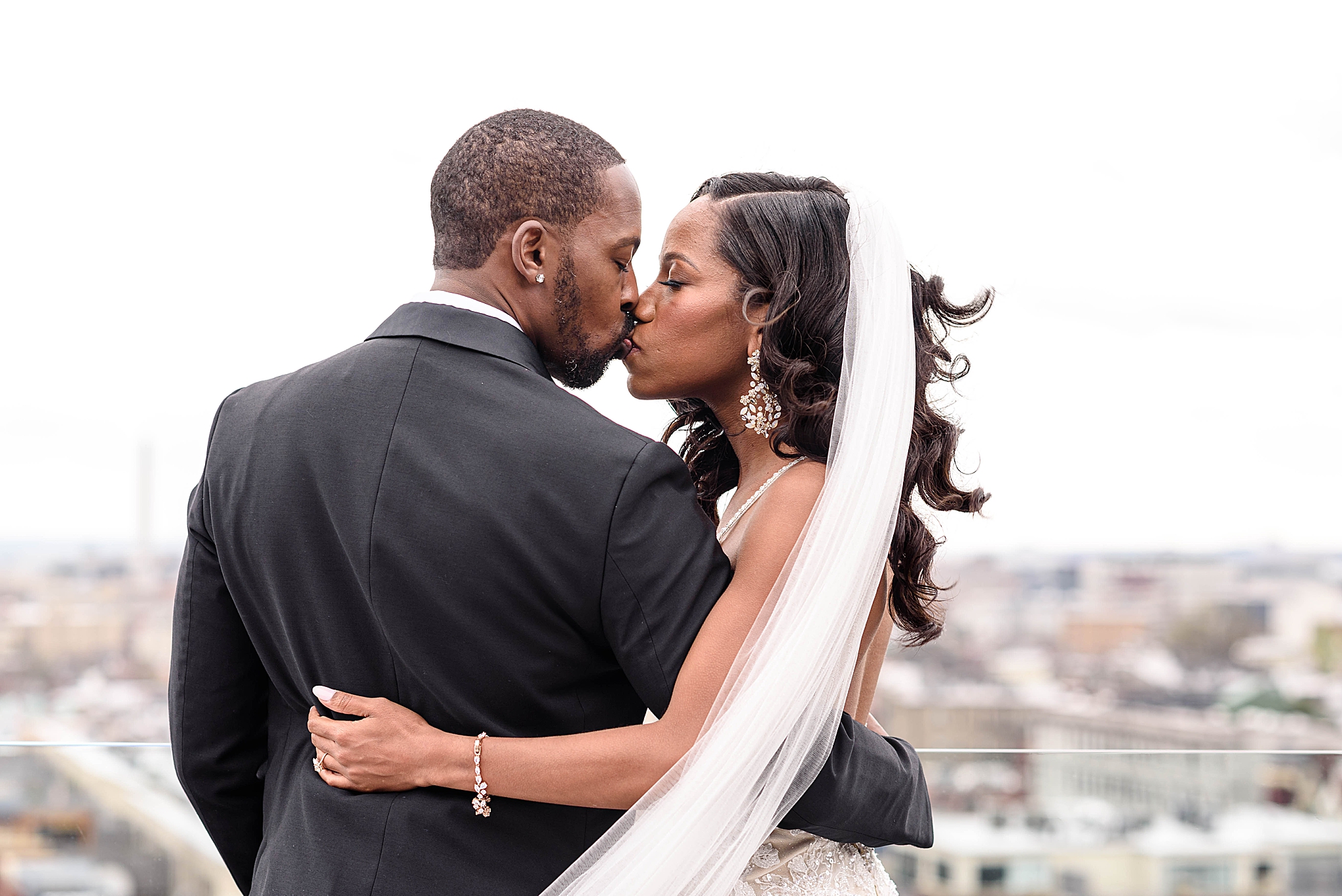 bride and groom kiss on Washington DC rooftop