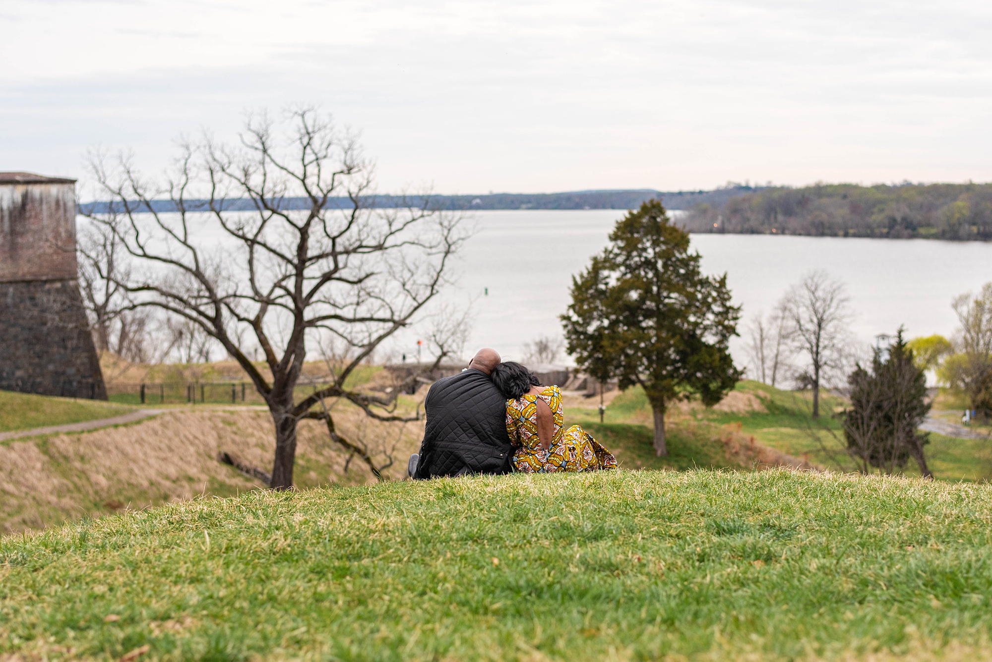 couple sits on hil lin Fort Washington Park