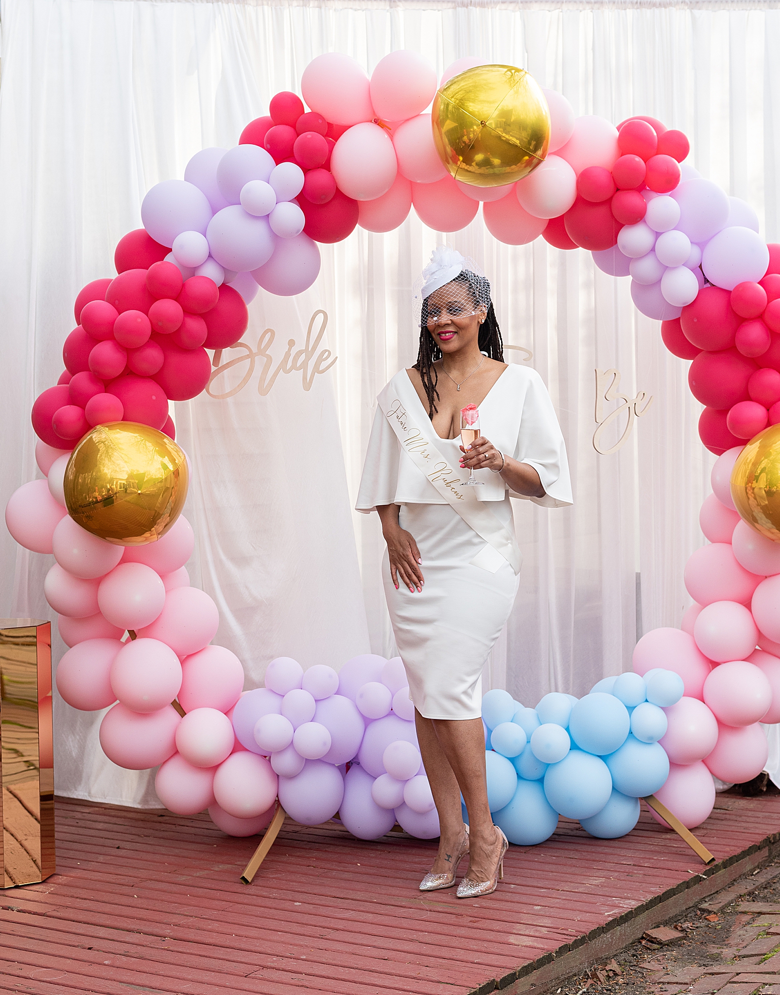 bride poses with balloon garland