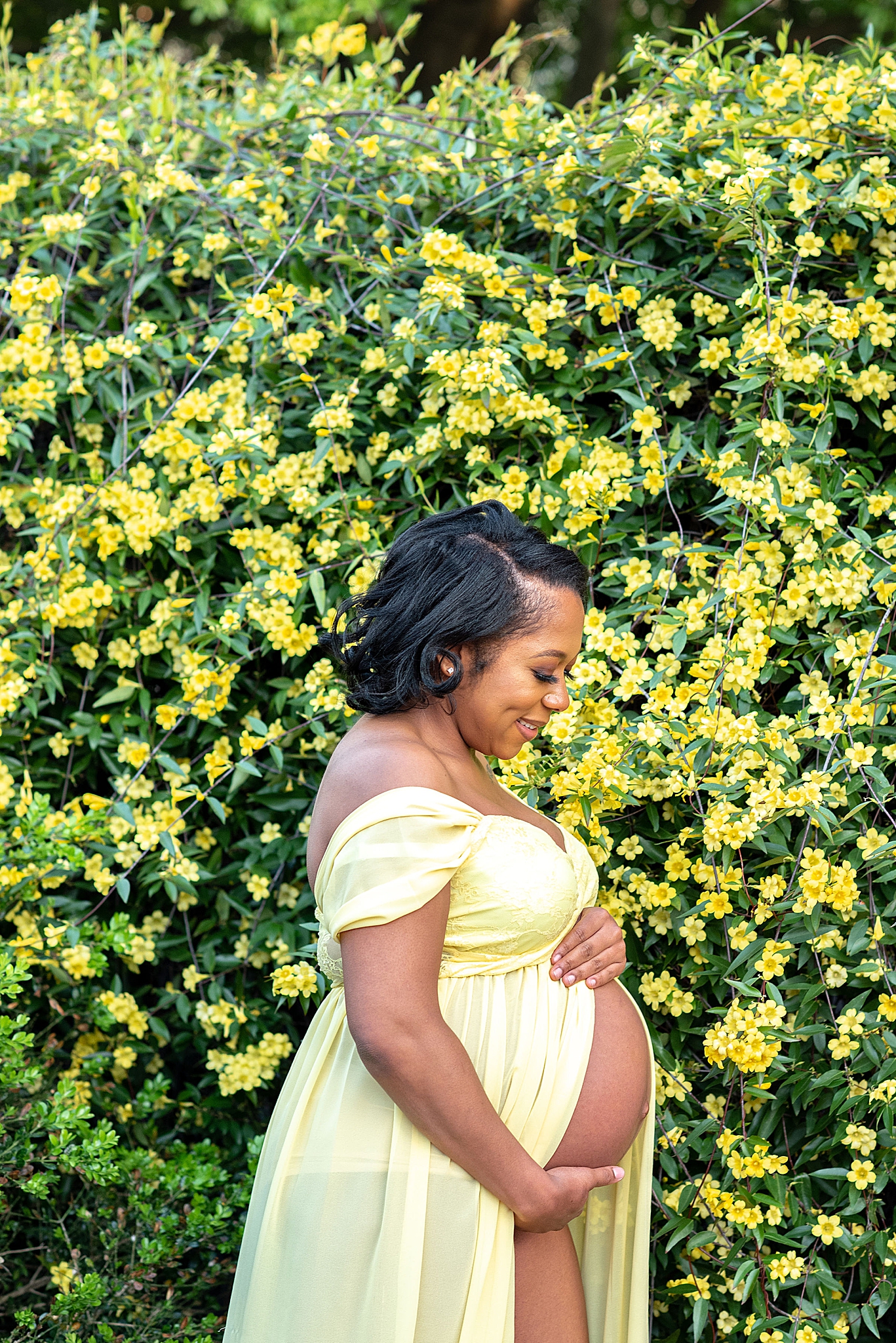 woman in yellow dress holds belly during DC maternity portraits