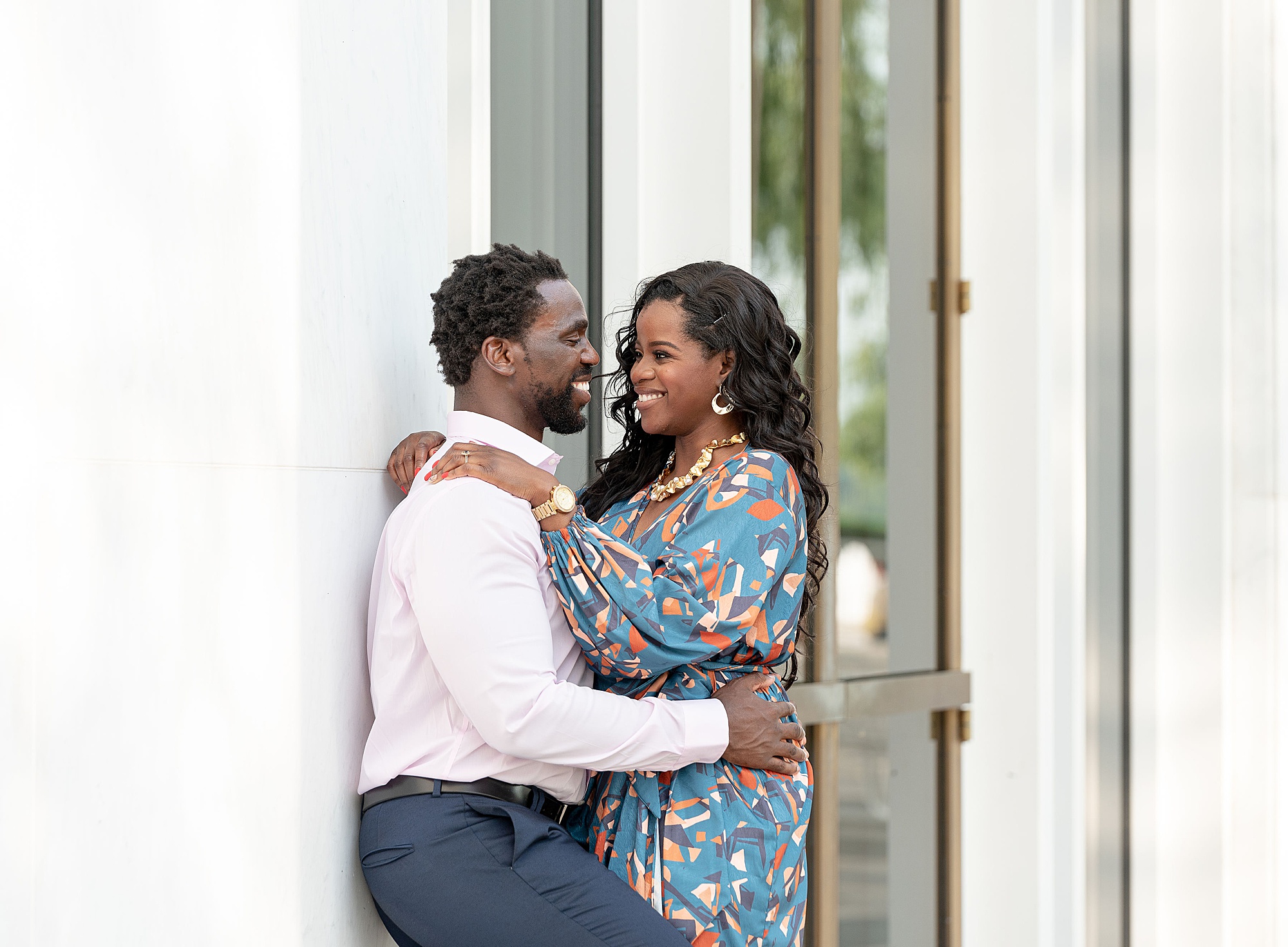 bride and groom hug by doors during Kennedy Center engagement session