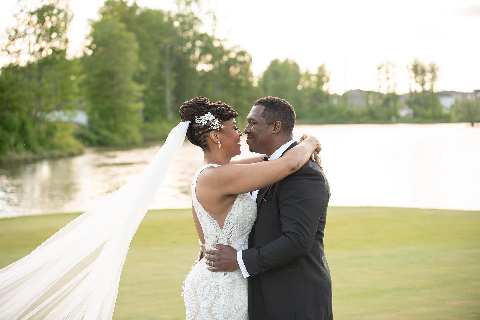 bride and groom hug on golf course during wedding photos 