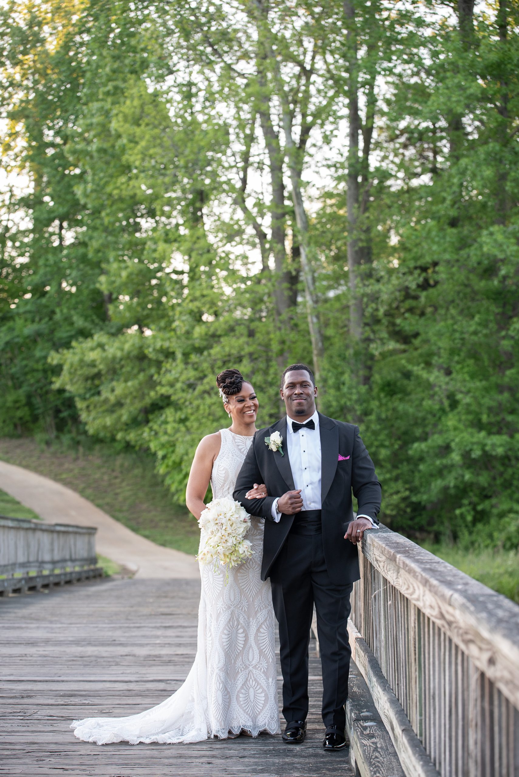 bride and groom pose on bridge in Marlboro MD