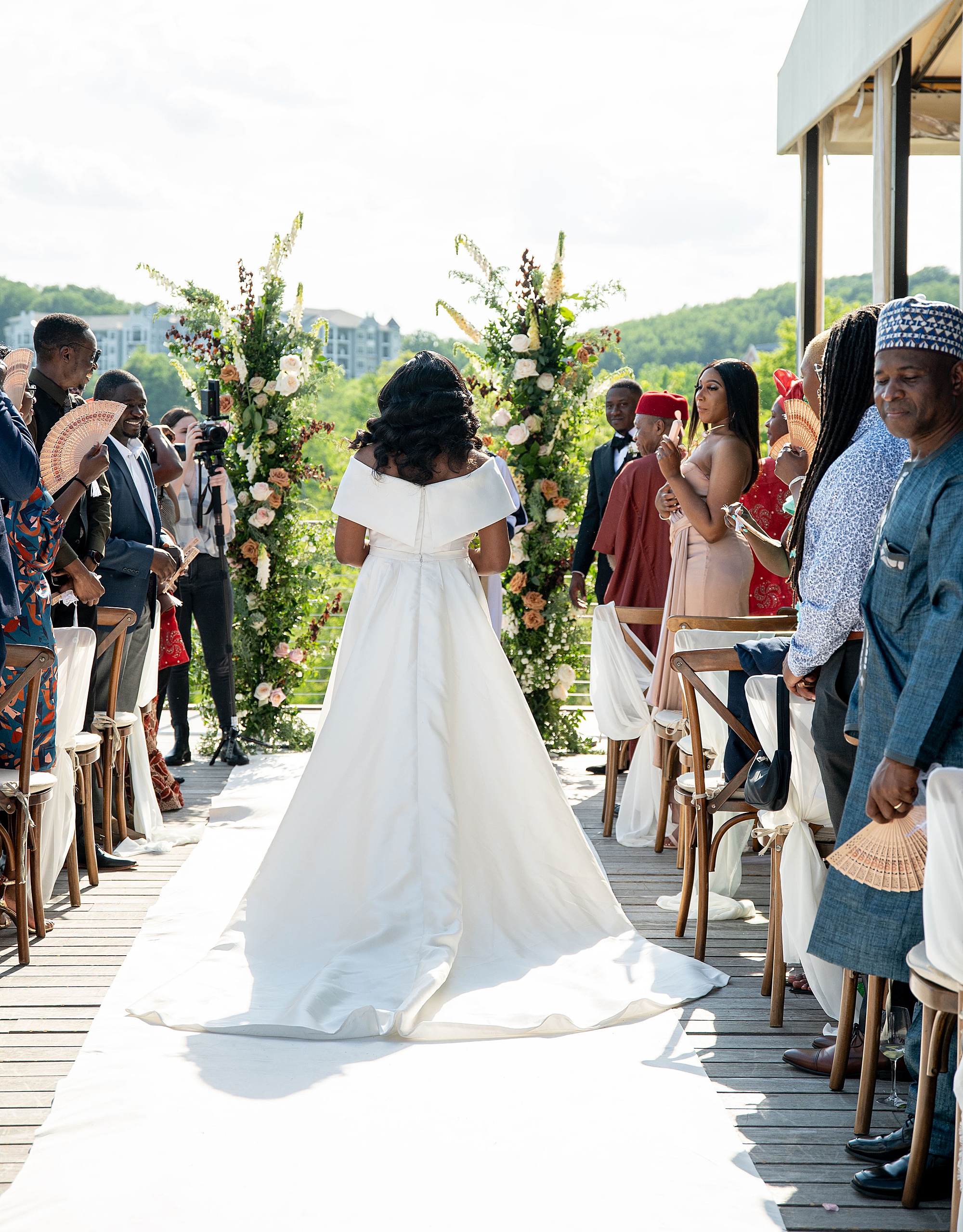 bride walks down aisle in classic wedding gown