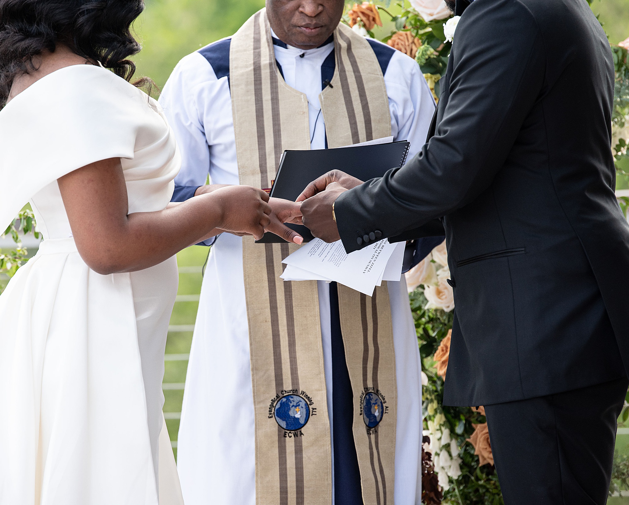 groom places ring on bride's finger during elegant Baltimore microwedding ceremony 