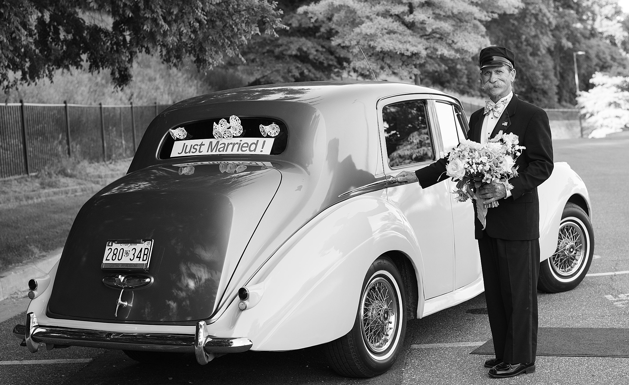 newlyweds stand with classic car after wedding