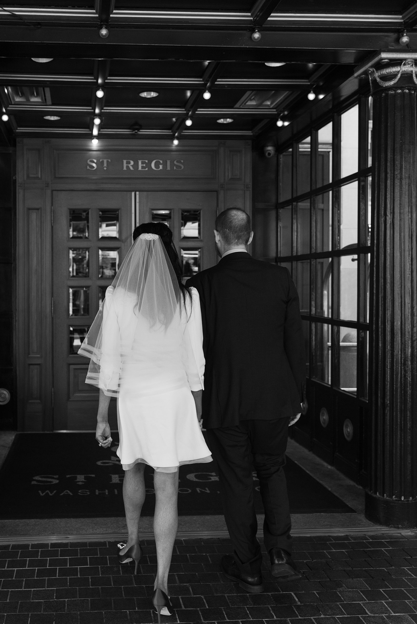 newlyweds walk into St. Regis Hotel