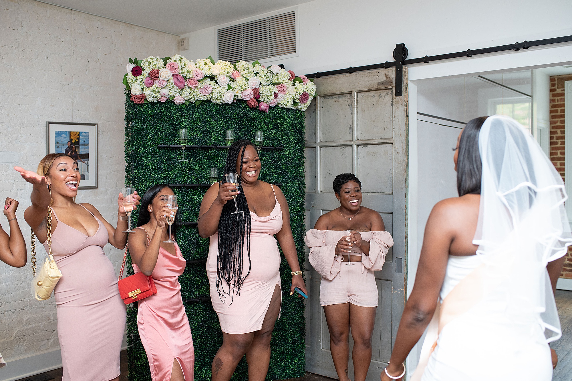 bridesmaids toast bride by champagne wall