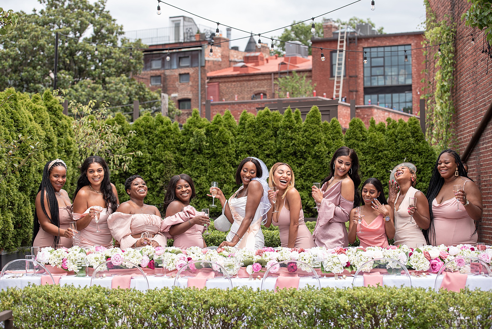bride poses at table with bridesmaids for DC bridal shower