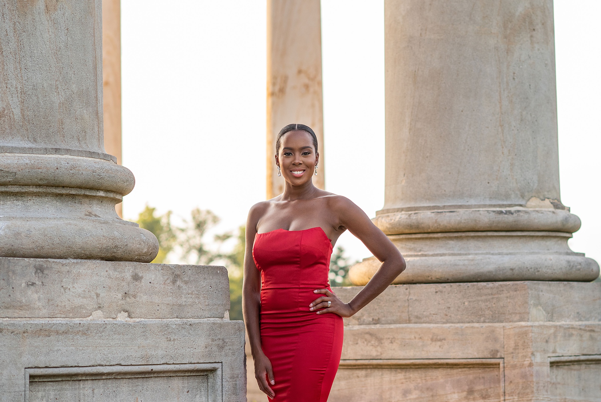 woman in red strapless dress poses with hand on hip