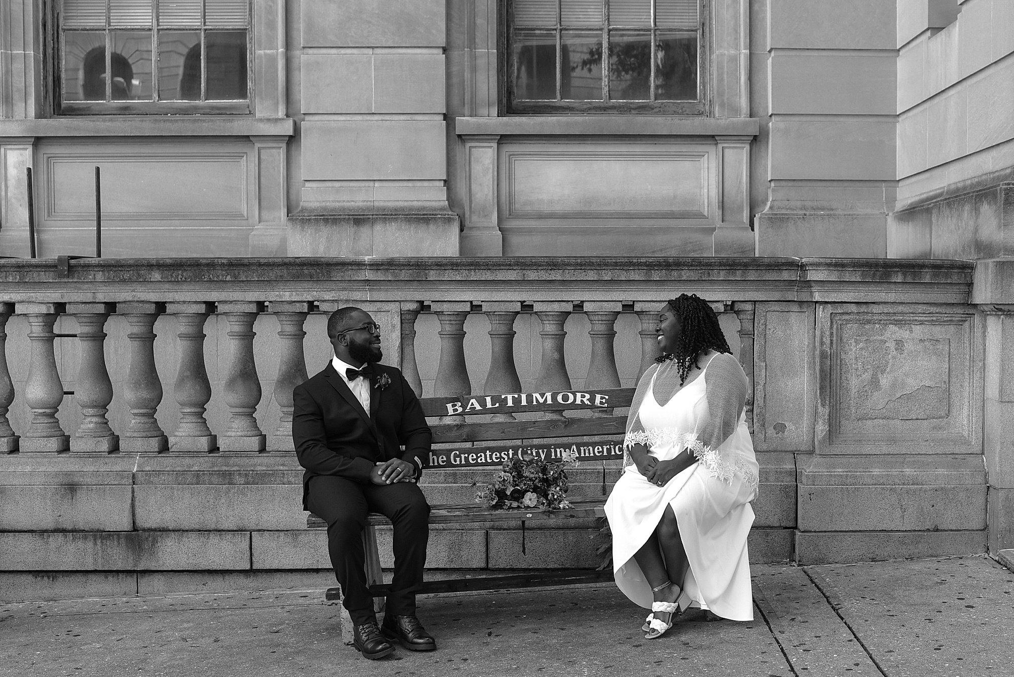 newlywed sit on wooden bench in Baltimore MD