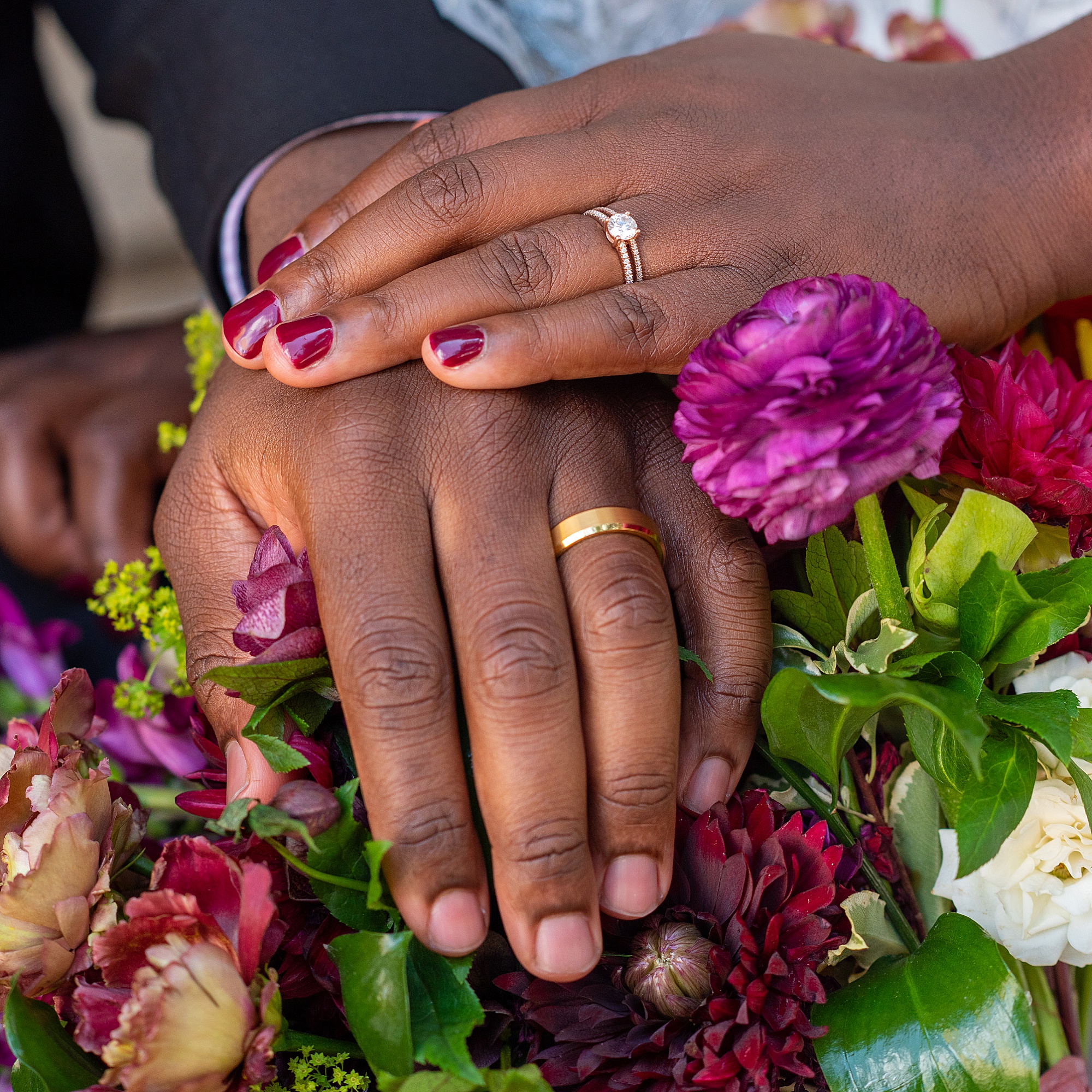 newlyweds place hands on flowers in Baltimore MD