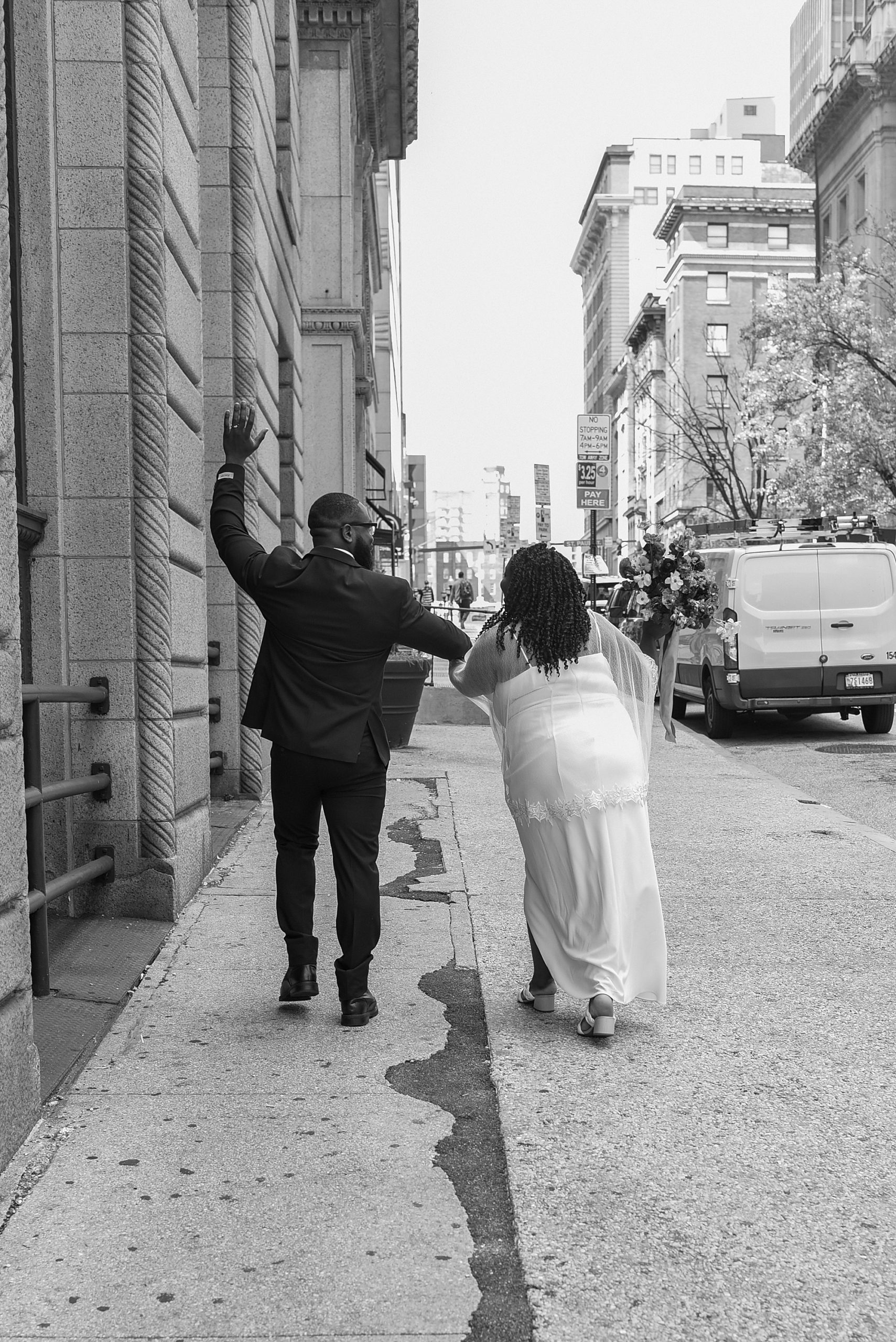 bride and groom wave walking down street