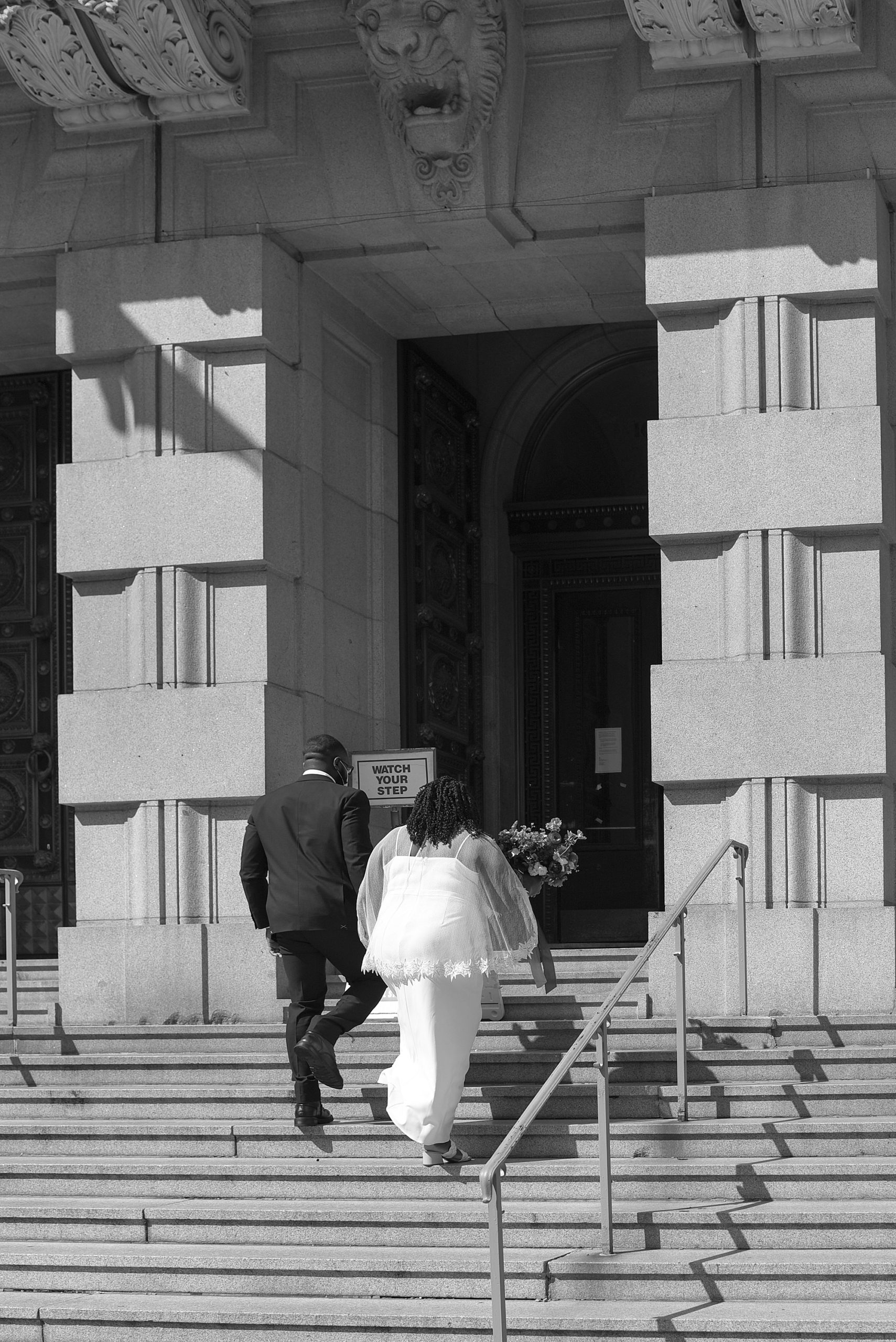 couple walks up steps to courthouse for elopement 