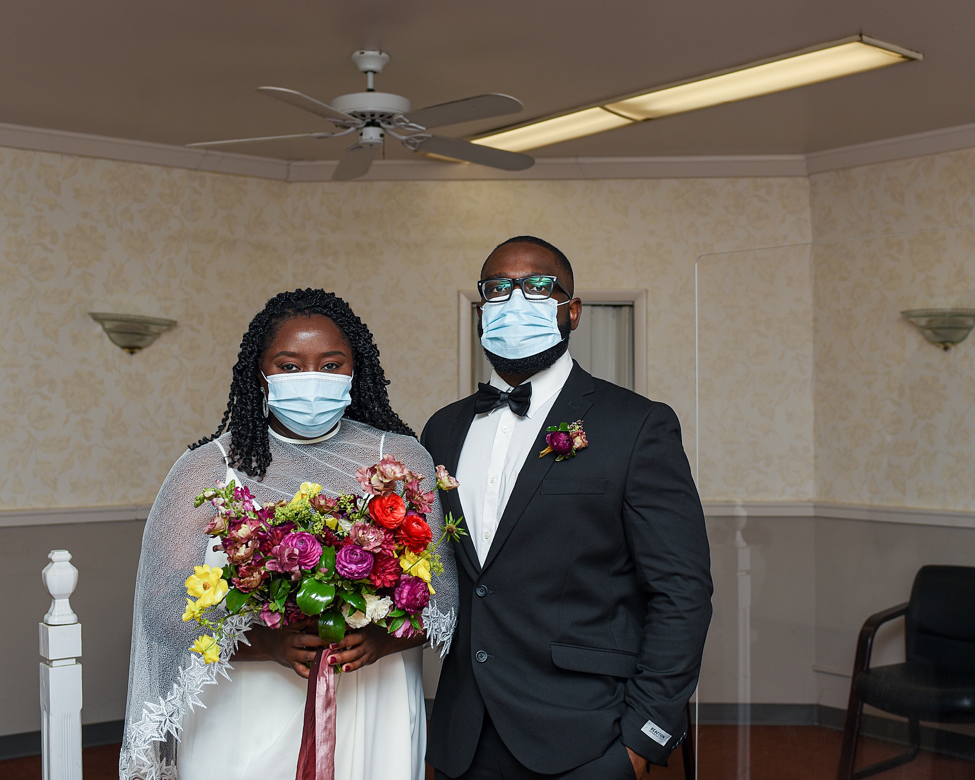bride and groom pose in masks during courthouse elopement 