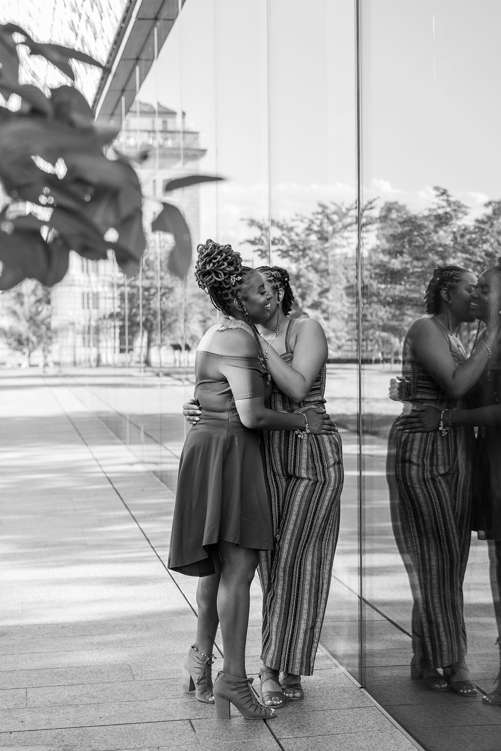 women hug by the National Museum of African American History and Culture