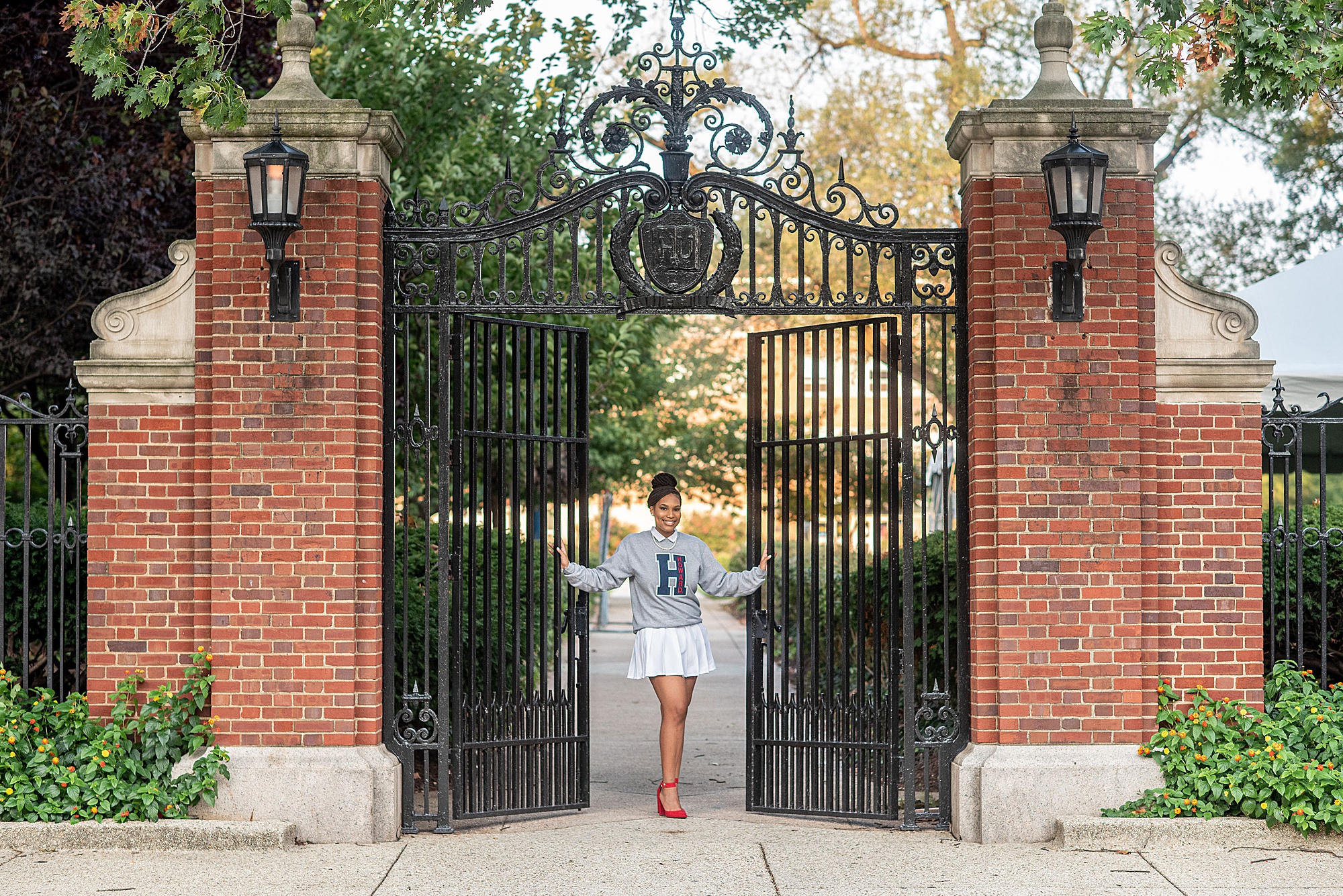 freshman stands between wrought iron gates at Howard University
