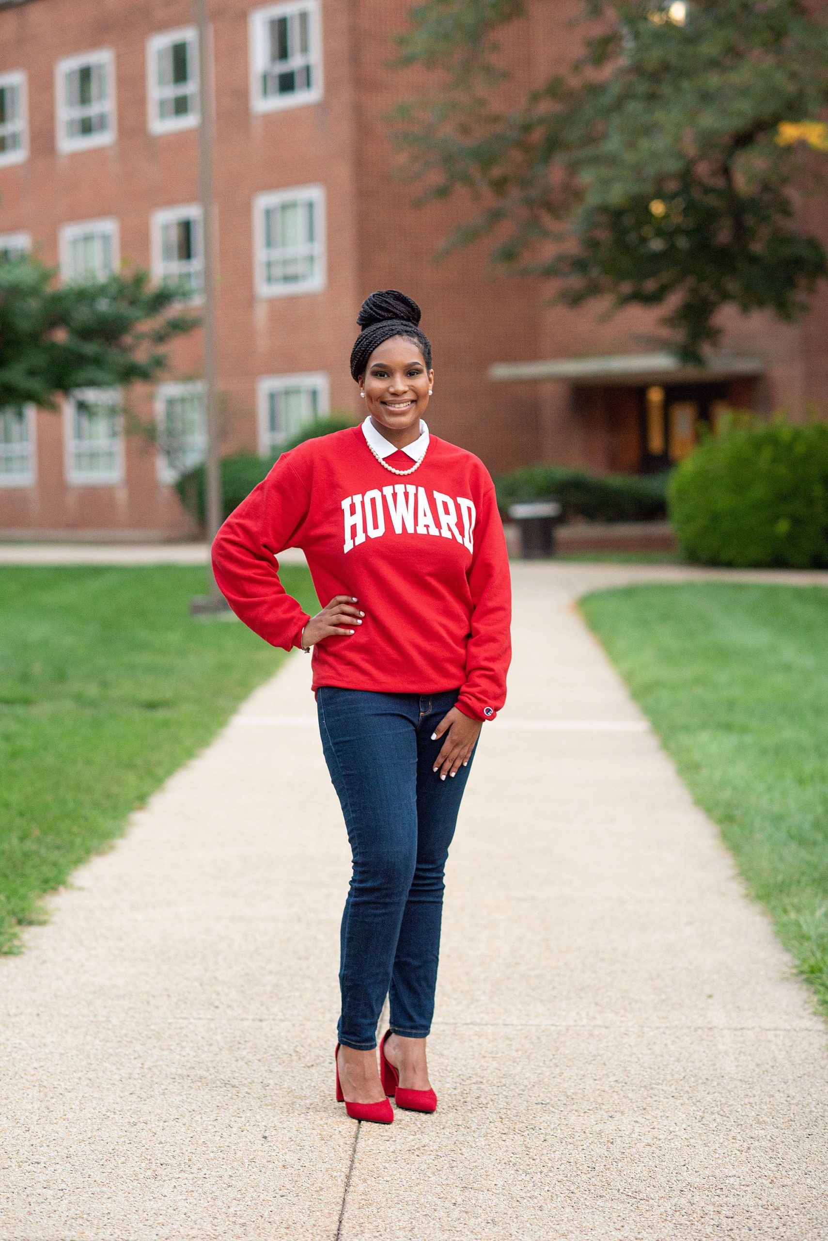 girl in Howard sweatshirt poses on campus during freshman photos