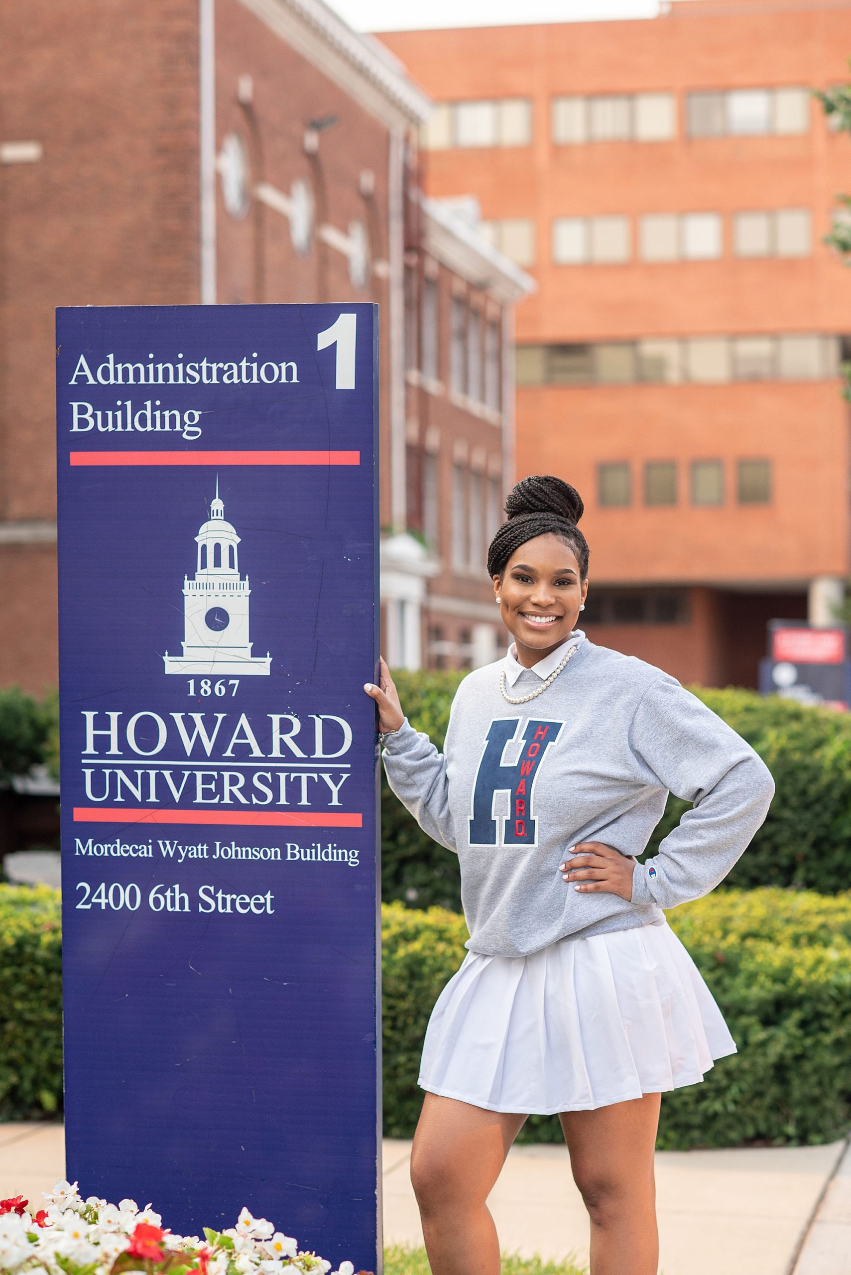 freshman poses with campus sign at Howard University