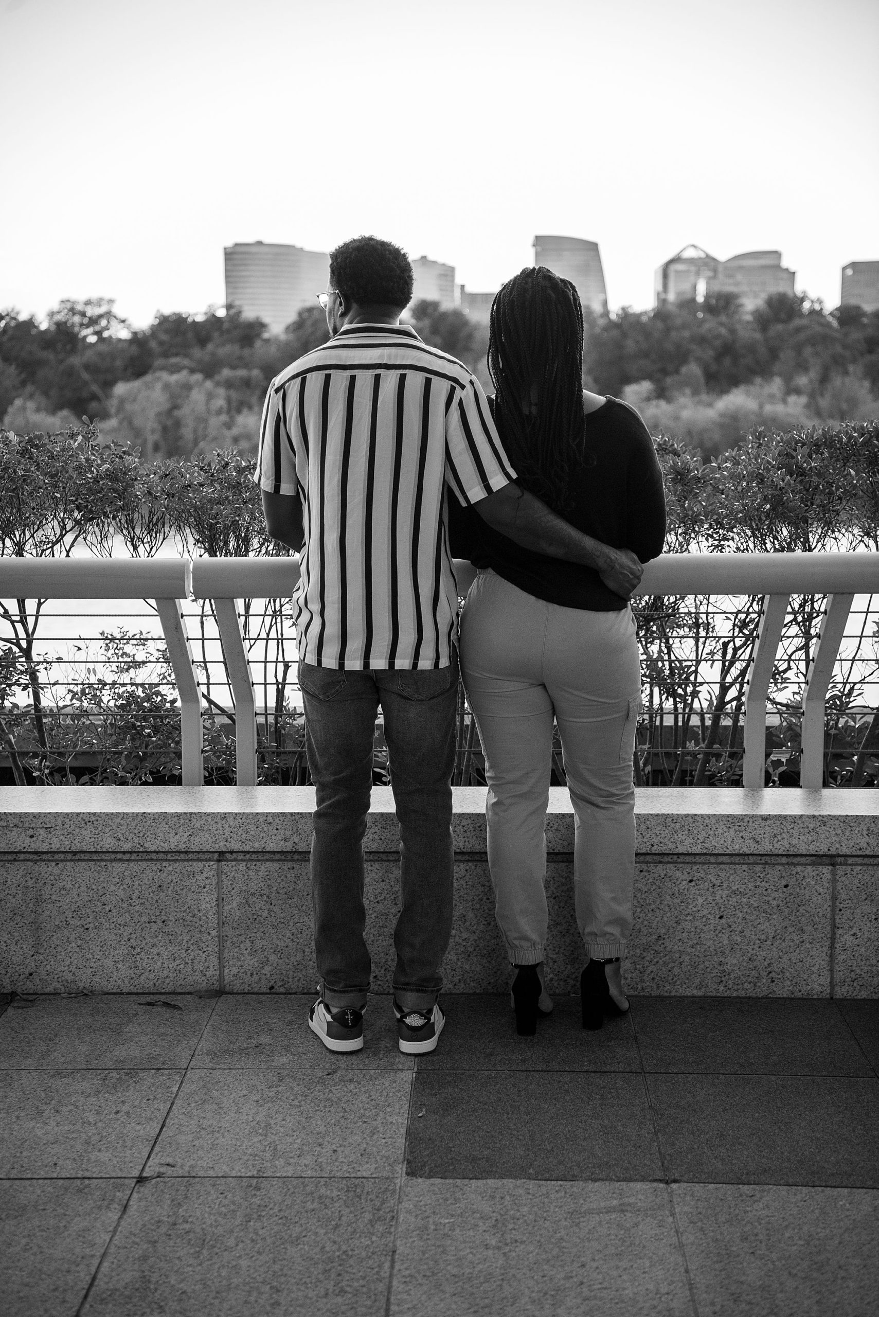 engaged couple looks at Washington DC from Kennedy Center balcony