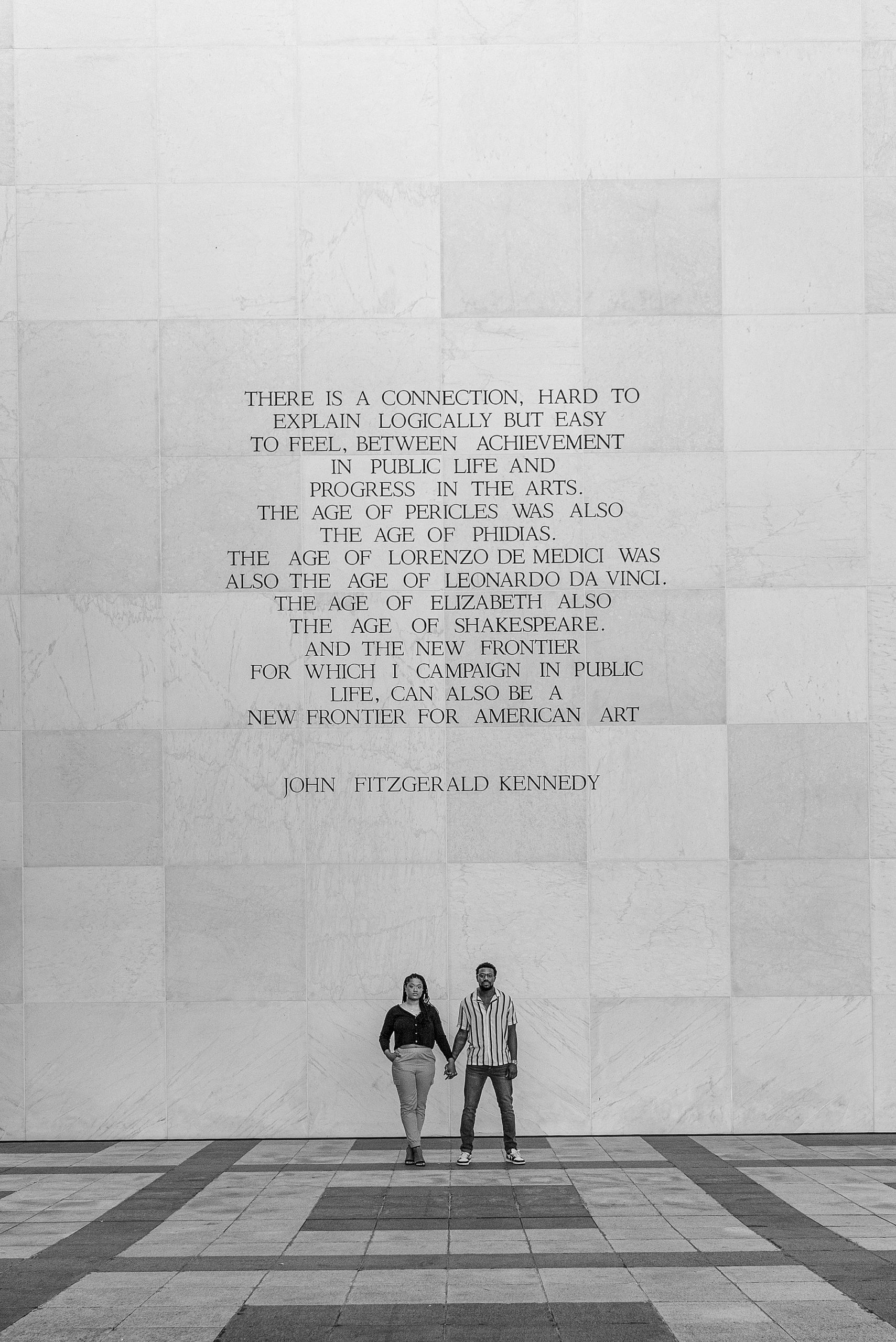 bride and groom hold hands under quote at the Kennedy Center