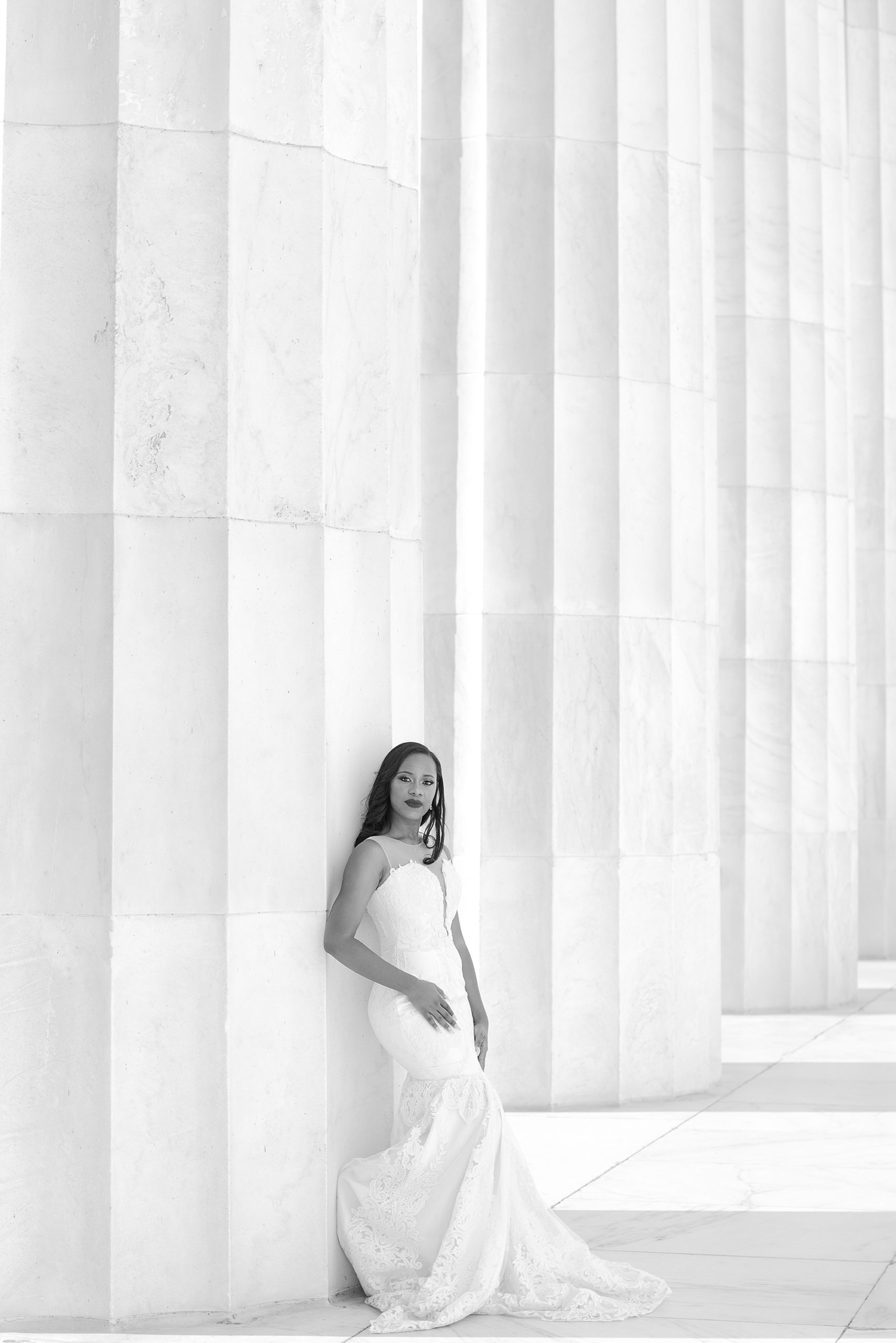 bride leans against columns of Lincoln Memorial