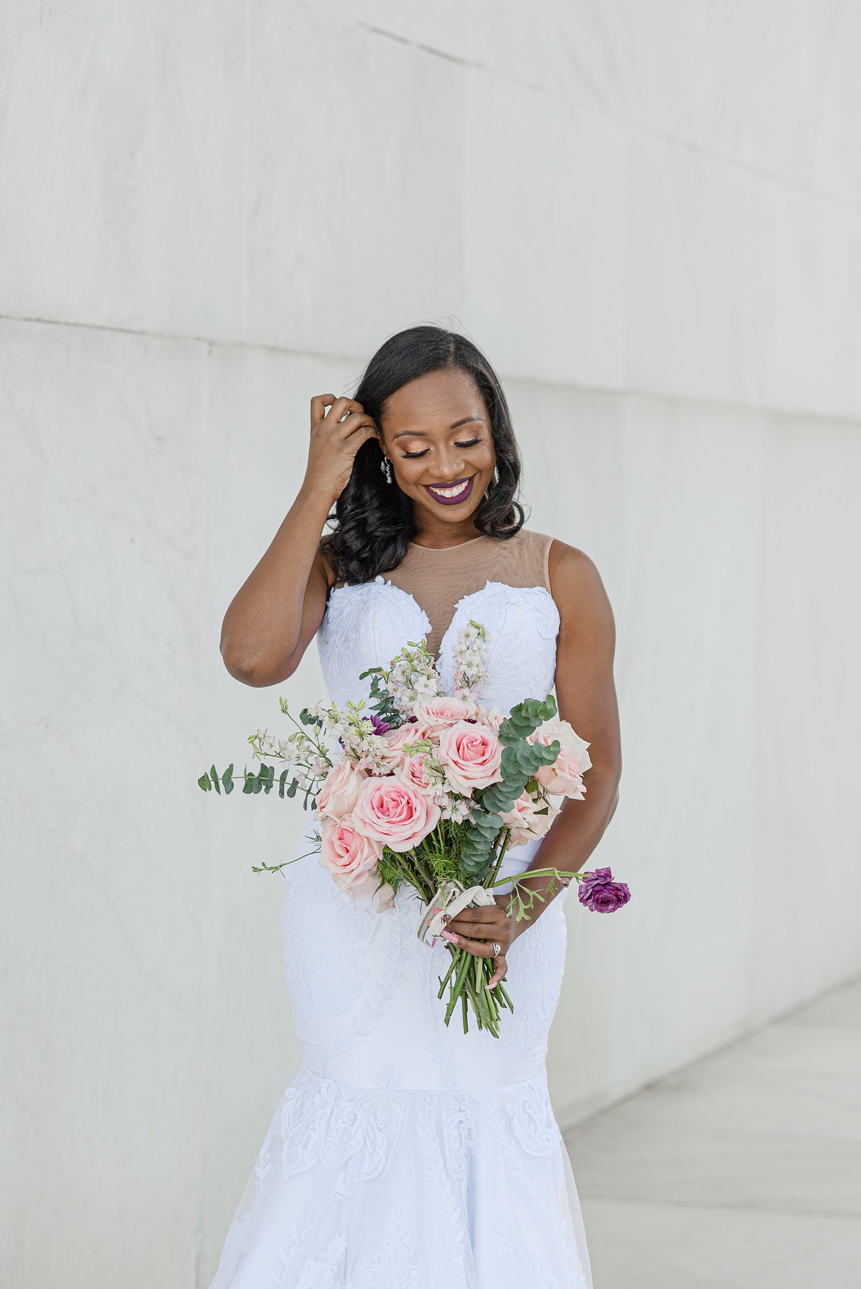 bride brushes hair behind her ear during Lincoln Memorial bridal portraits