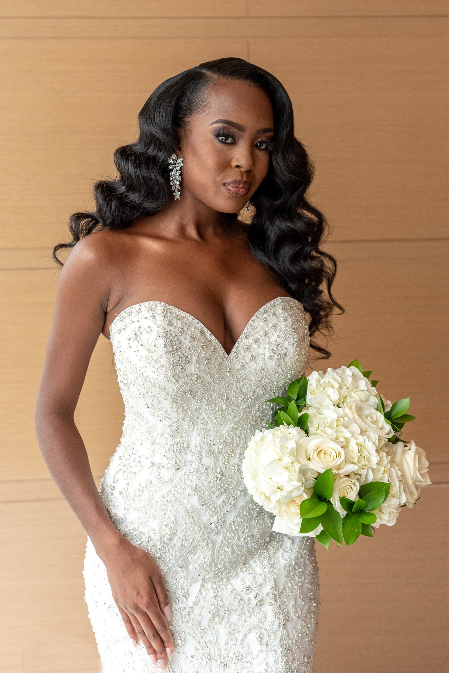 bride poses with bouquet of white flowers 