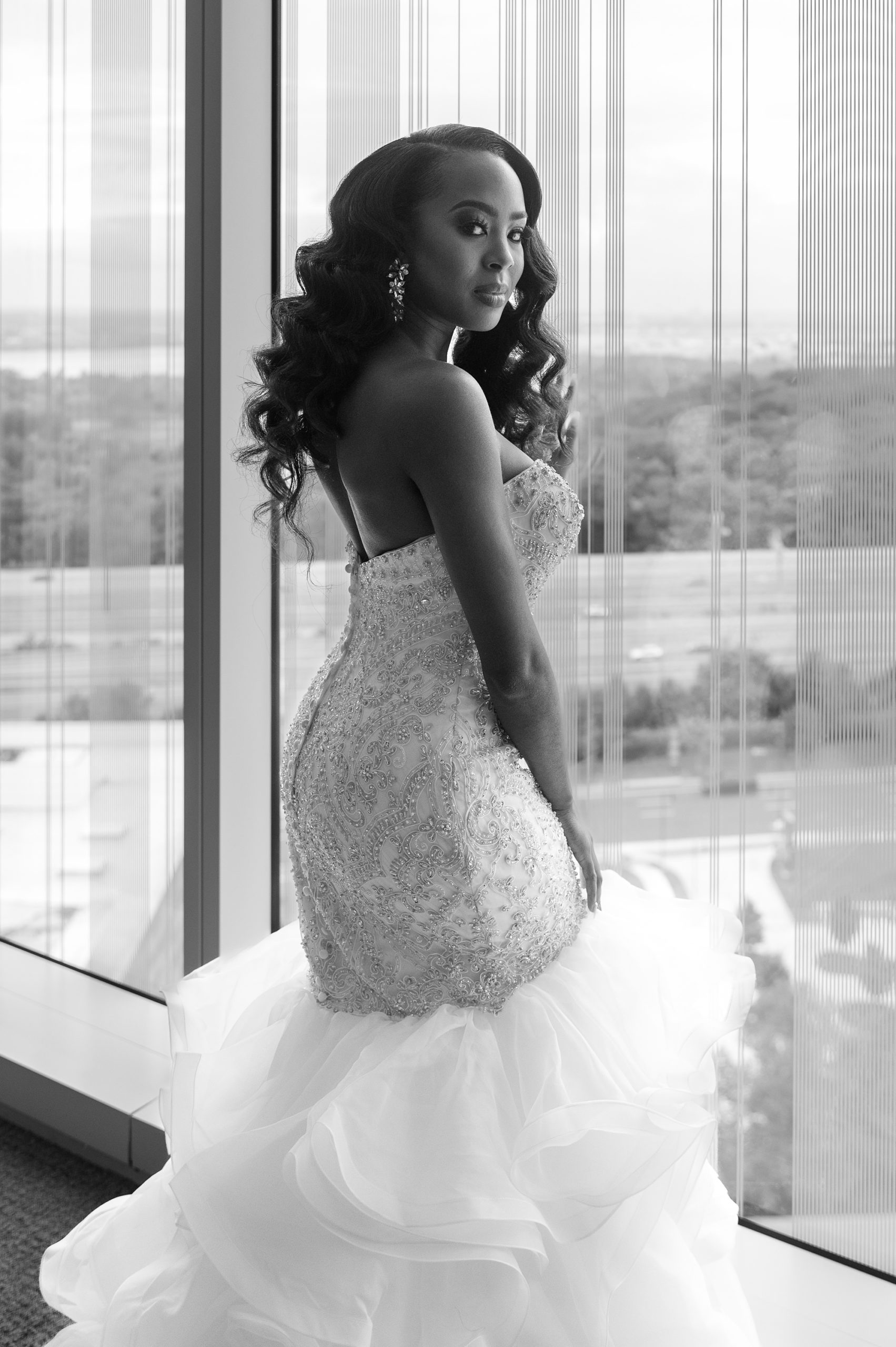 bride stands in window looking over Washington DC
