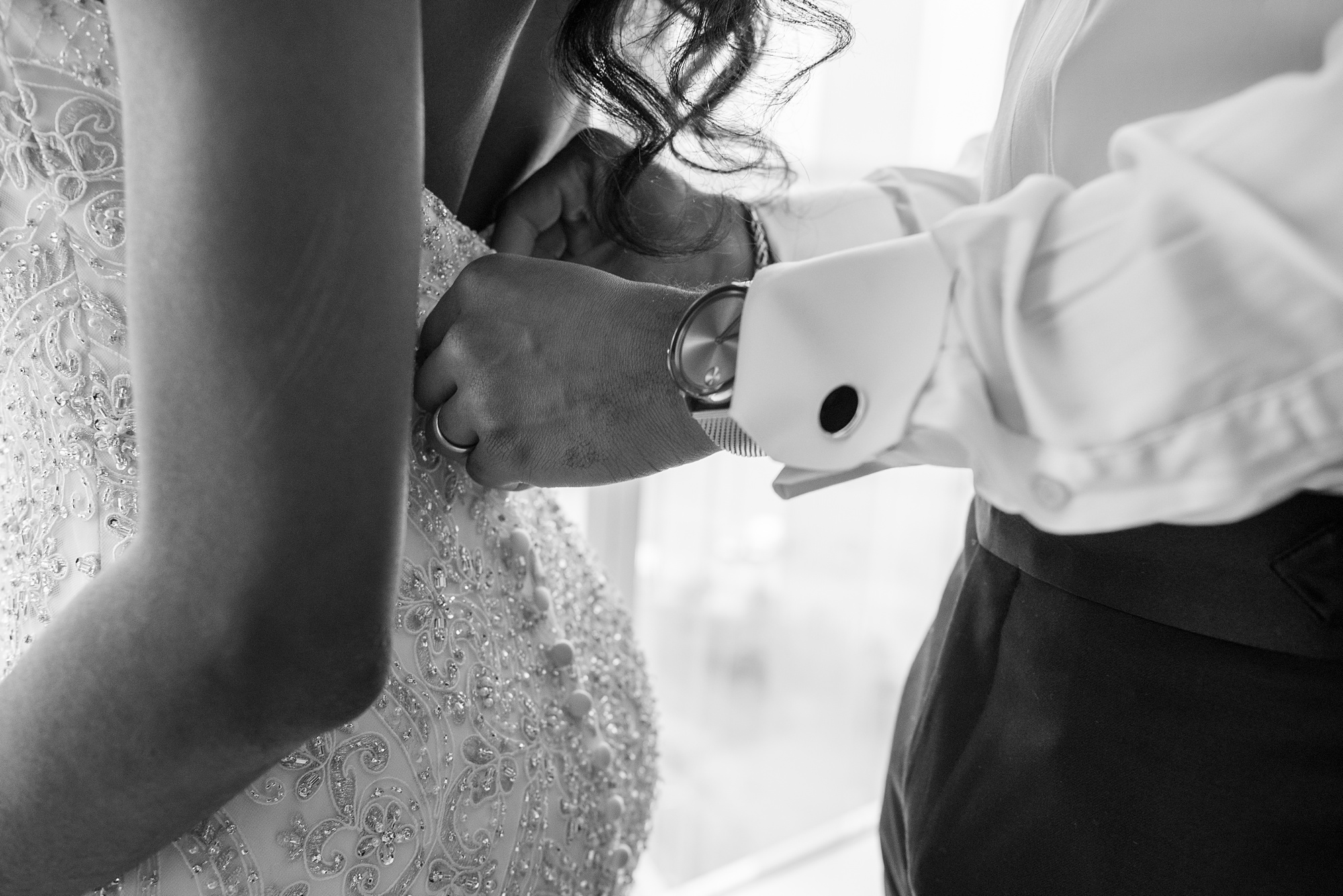 groom helps button bride's gown before The Spirit of Washington wedding reception 
