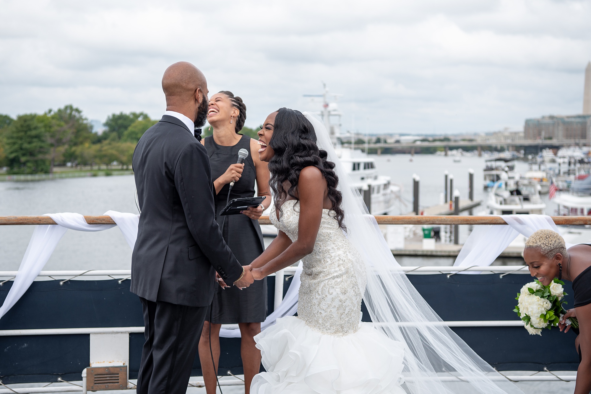 bride and groom laugh during wedding ceremony on boat