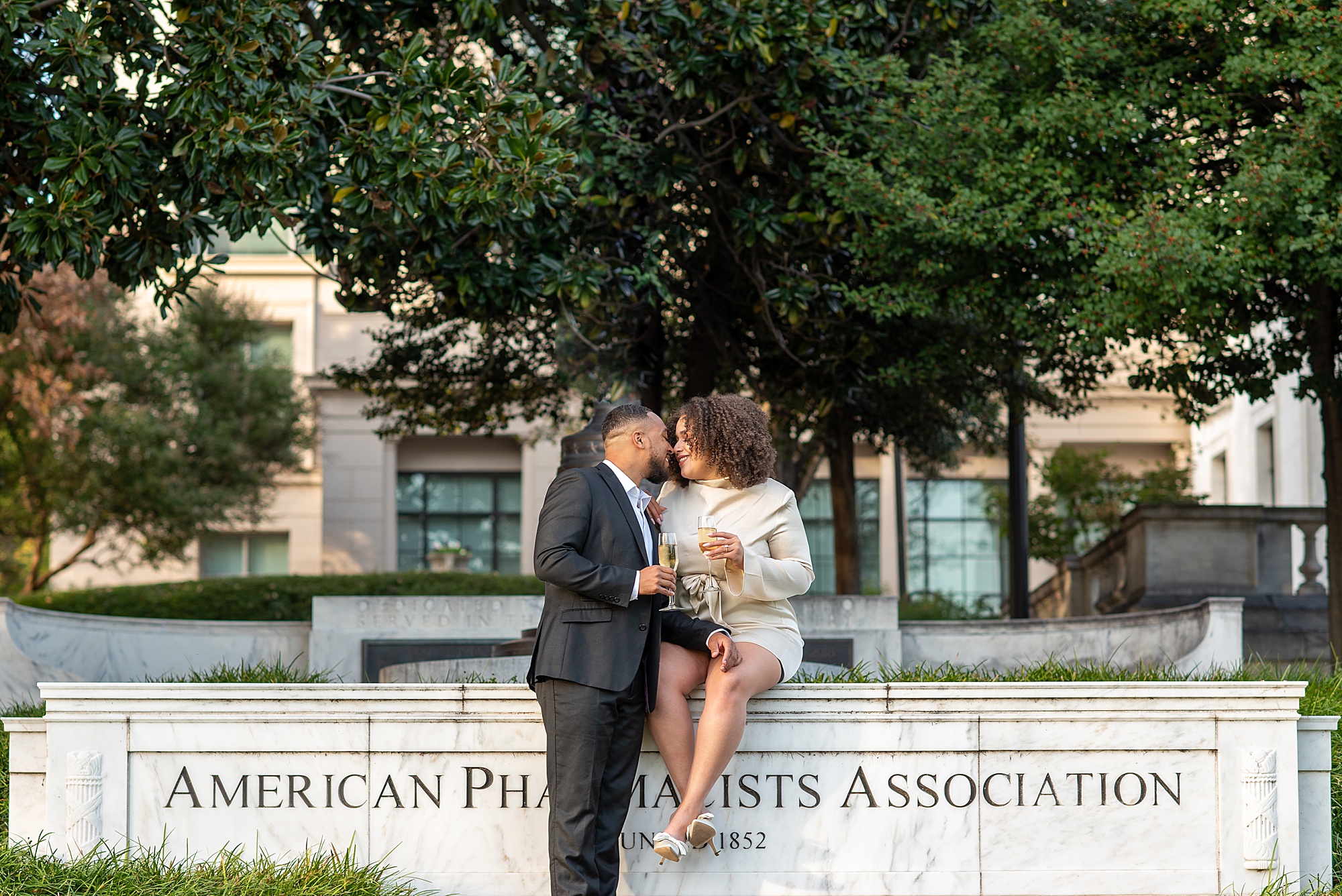 bride sits on American Pharmacist Association sign at building in DC