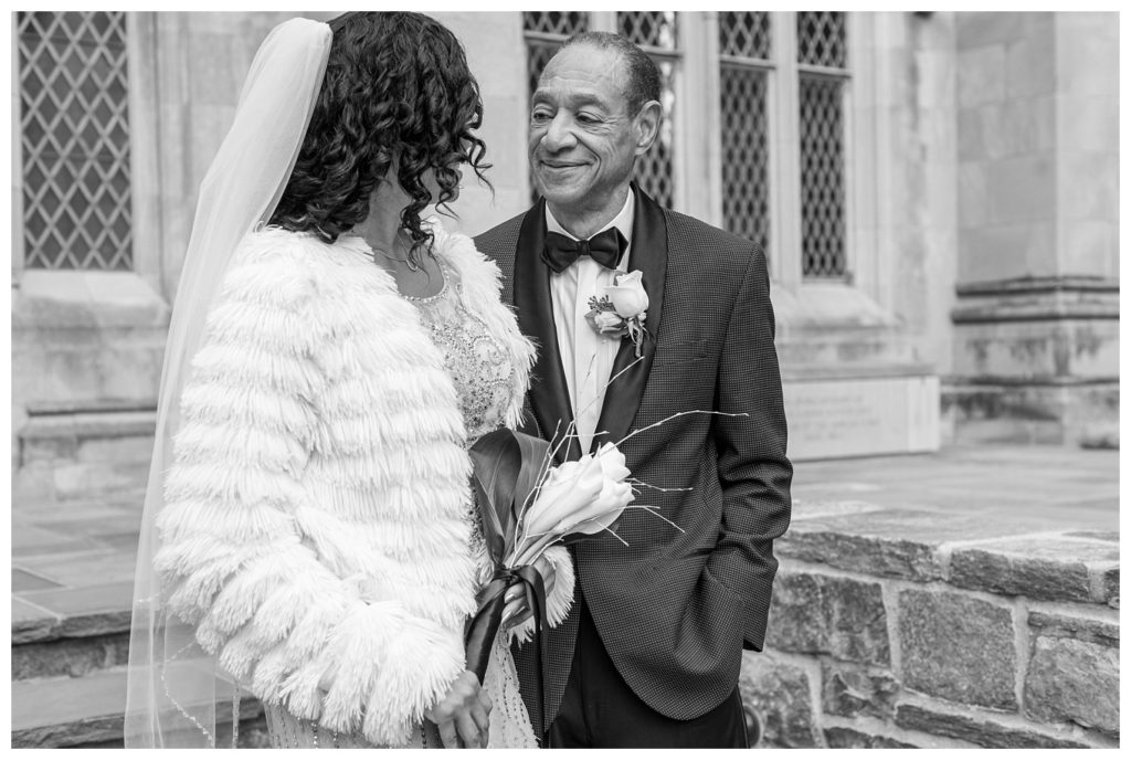 black and white of bride and groom posing in front of church in D.C.