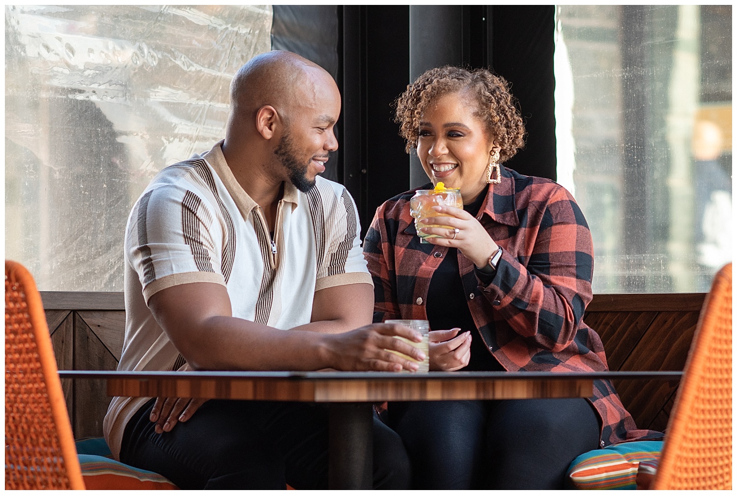 couple sitting at a table with drinks during engagement session