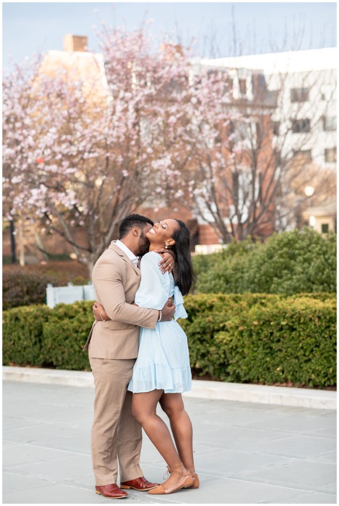 couple laughing and hugging near cherry blossom trees in Washington D.C.