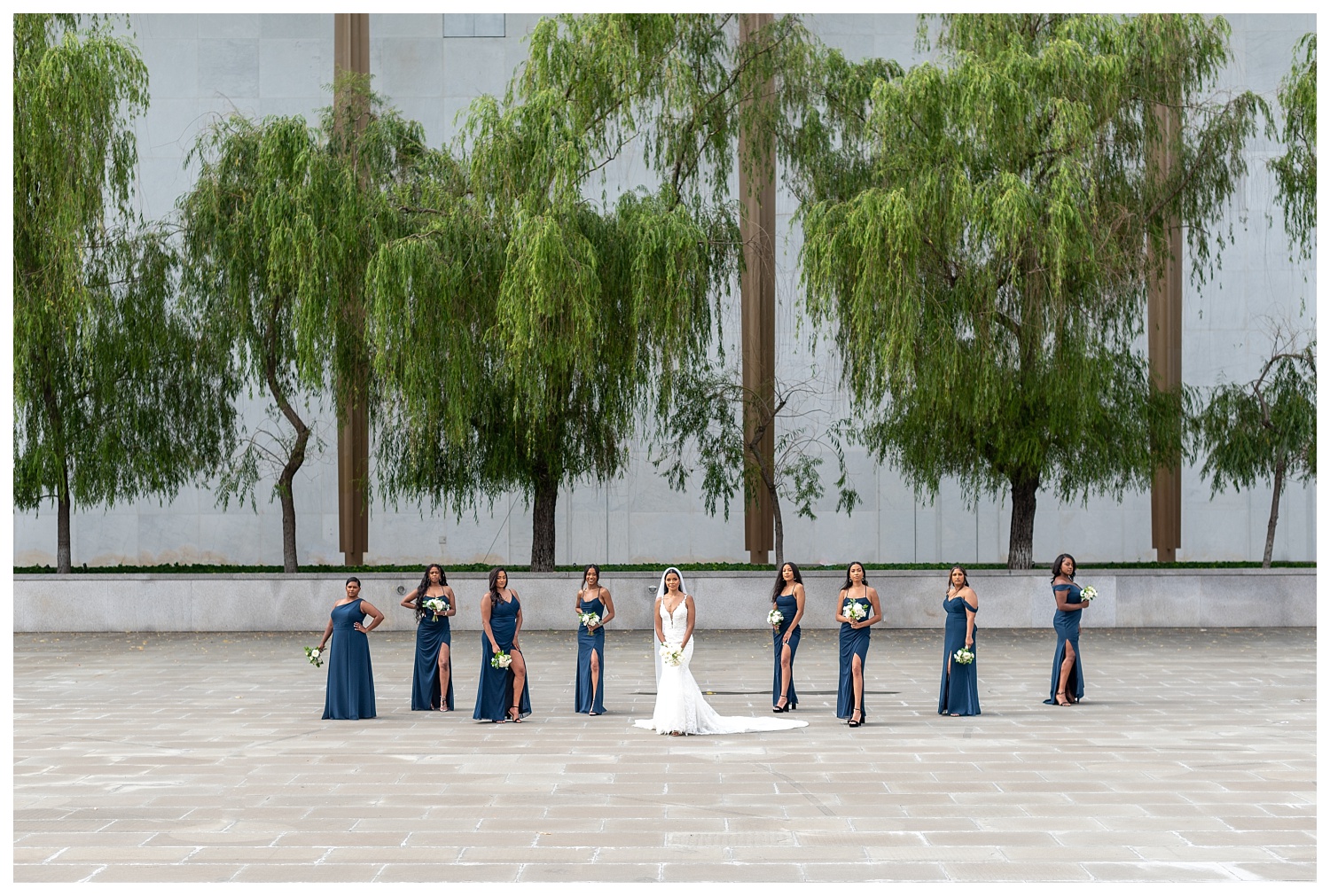 bride and bridesmaids posing together in front of the Kennedy Center in Washington, D.C.