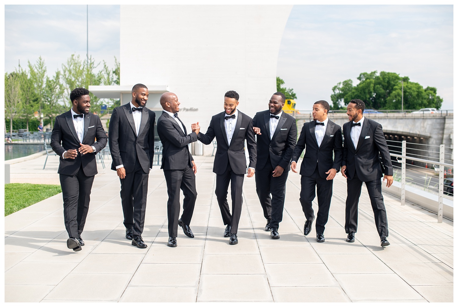 groom and groomsmen walking together at the Kennedy Center in Washington, D.C.