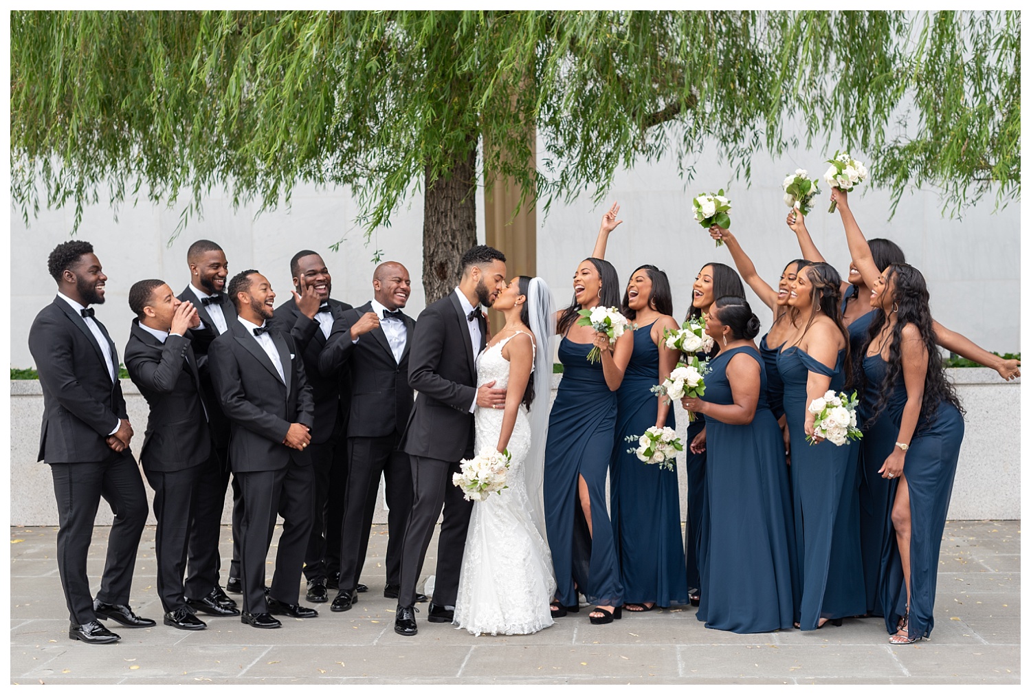 wedding couple kissing as bridal party cheers for them in Washington, D.C.