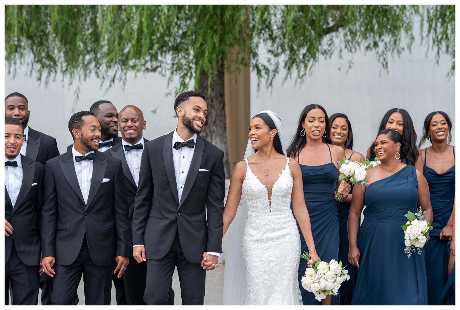 wedding couple walking together with bridal party at Kennedy Center