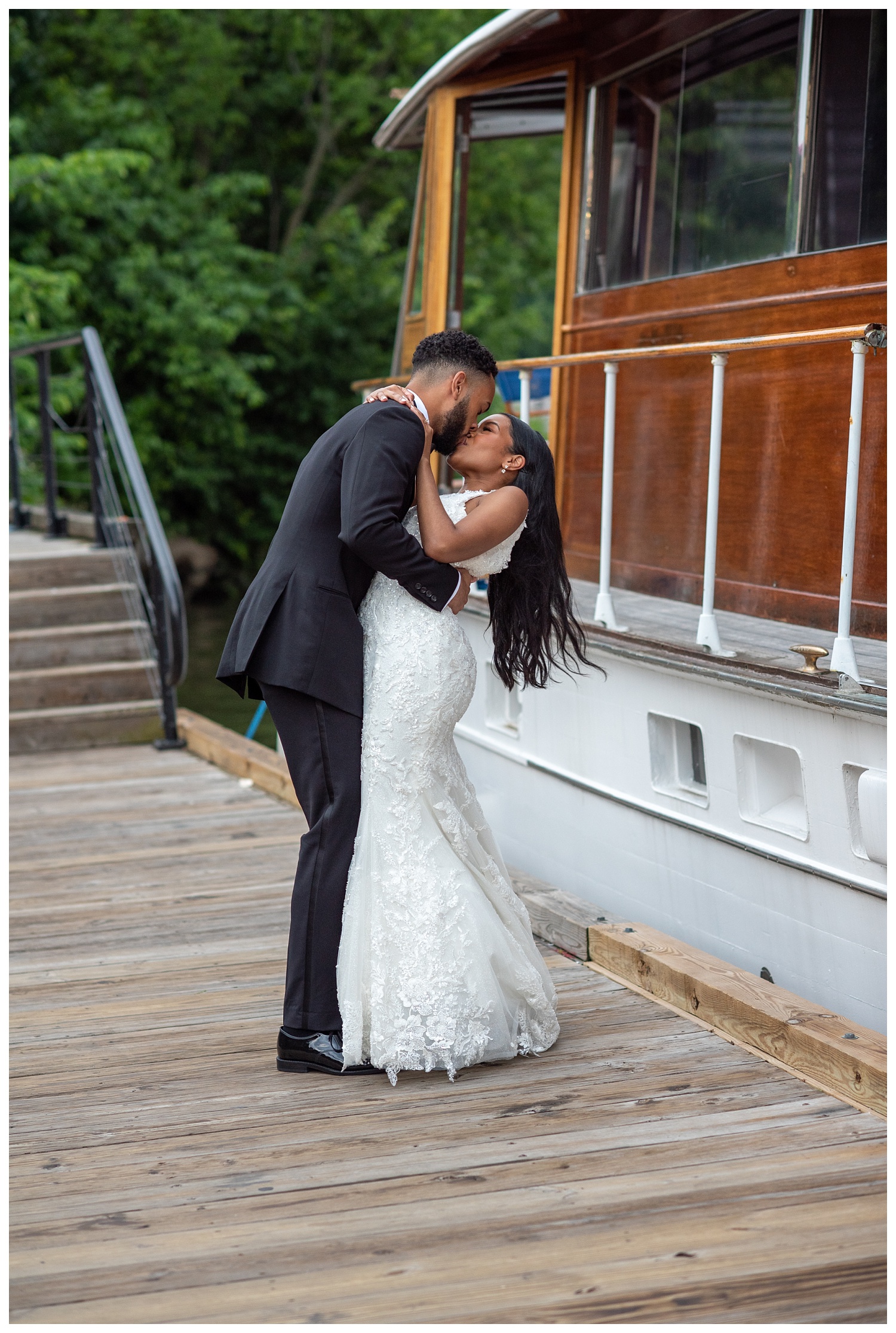 groom dipping the bride along the waterfront next to a boat