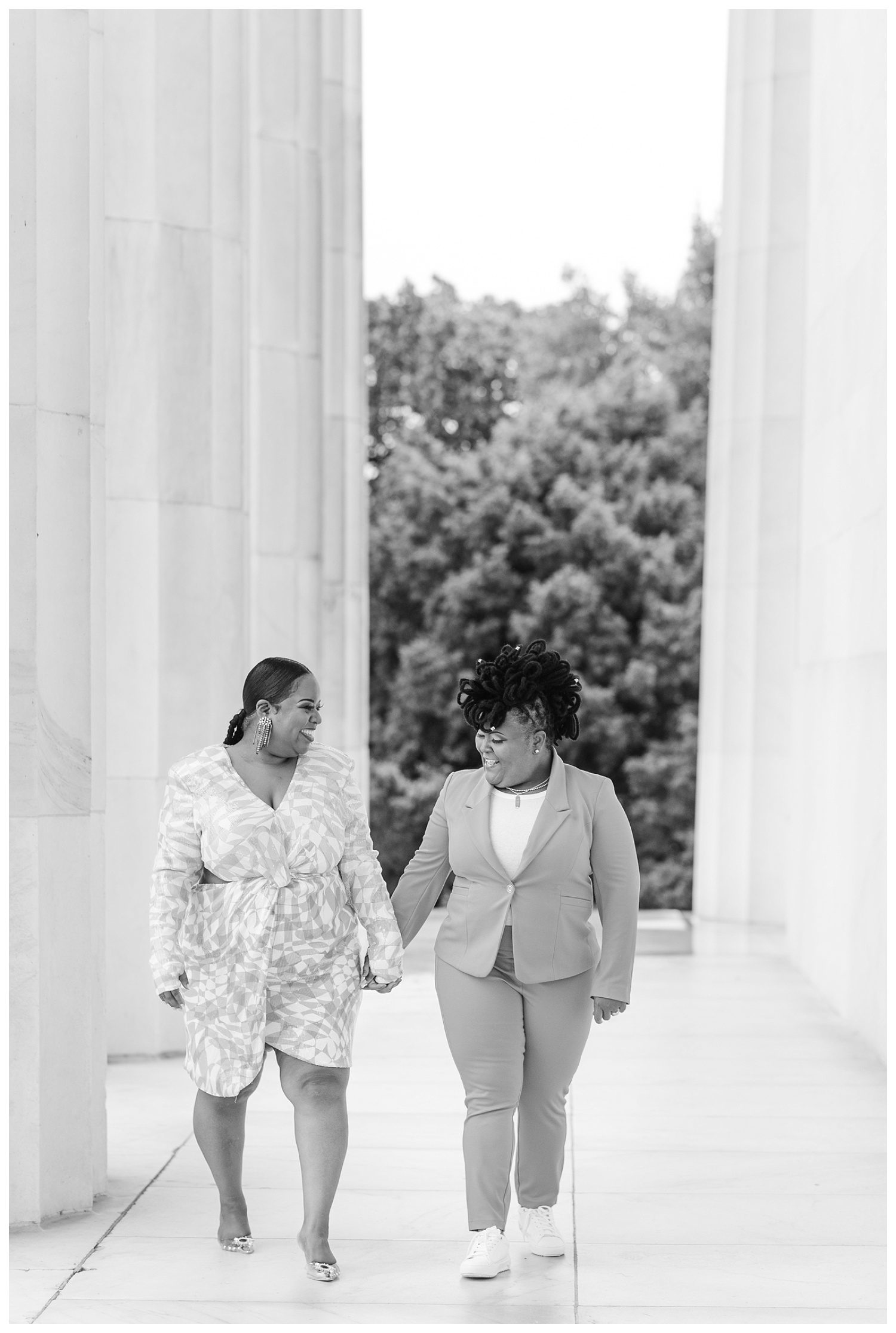 couple walking under columns at engagement session