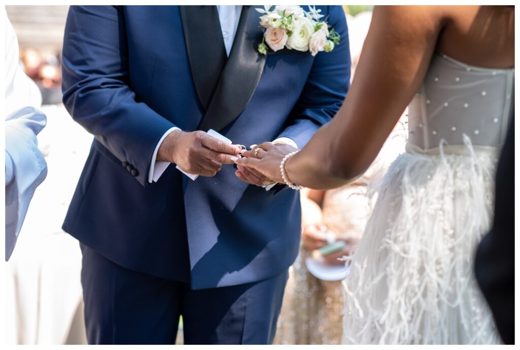 groom placing ring on bride's finger at morning wedding ceremony