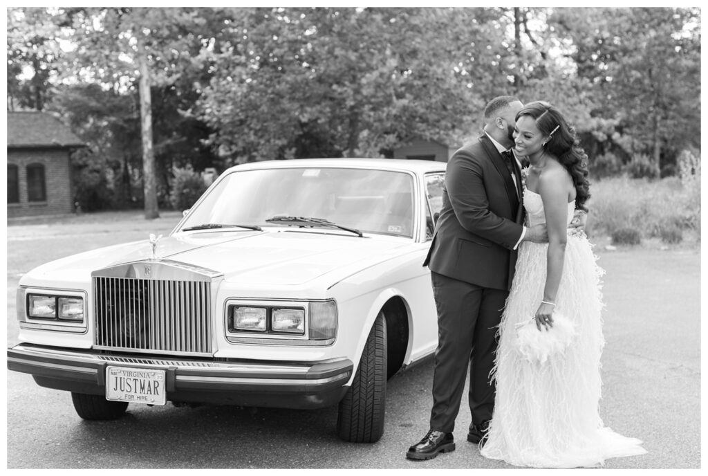 bride and groom pose in front of white classic car at reception